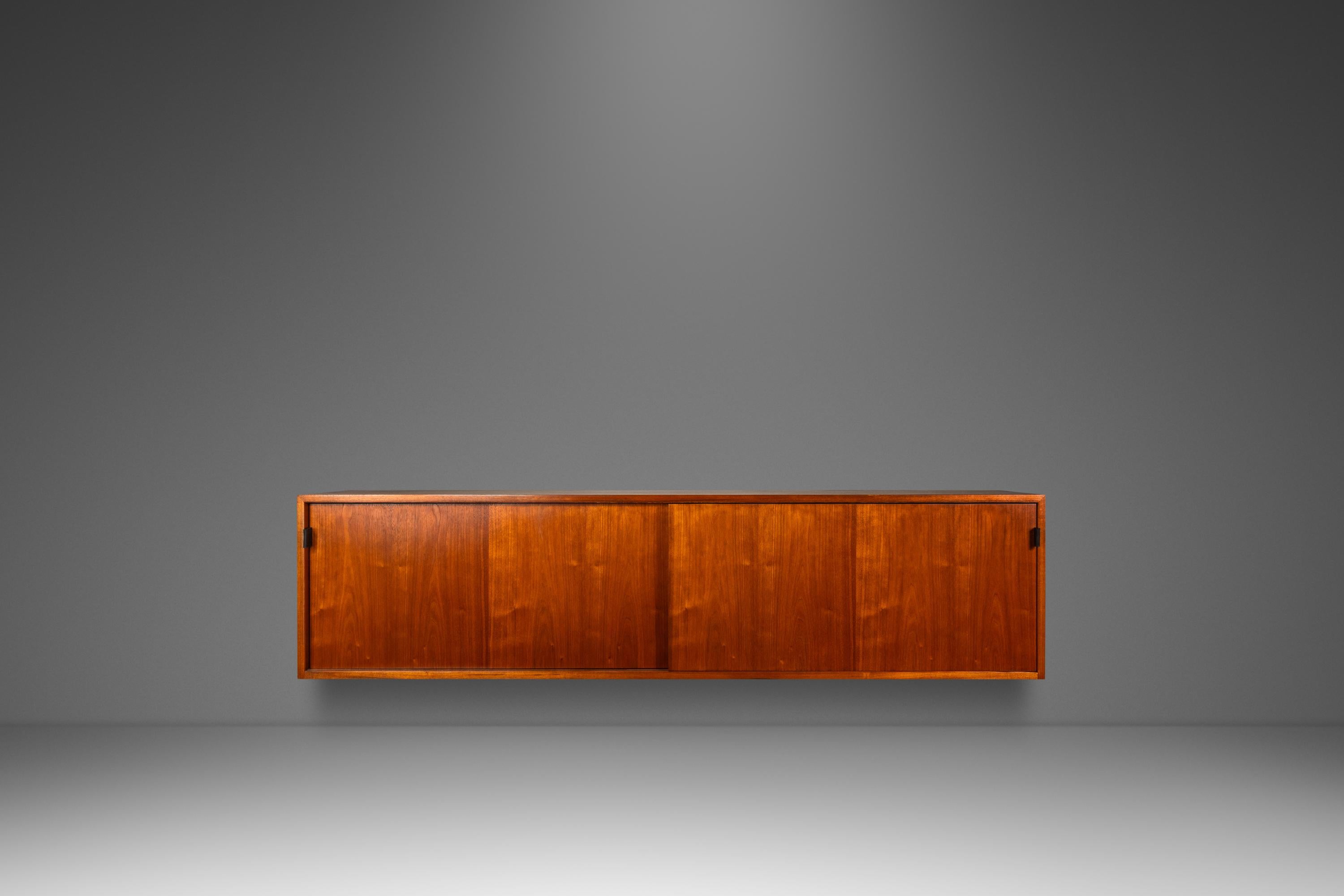 Este icónico armario de pared Moderno de Mediados de Siglo, Modelo 123 W-1, diseñado por Florence Knoll para Knoll Associates en la década de 1950, ejemplifica el sofisticado diseño americano. Con estantes ajustables de madera y cristal, frentes de
