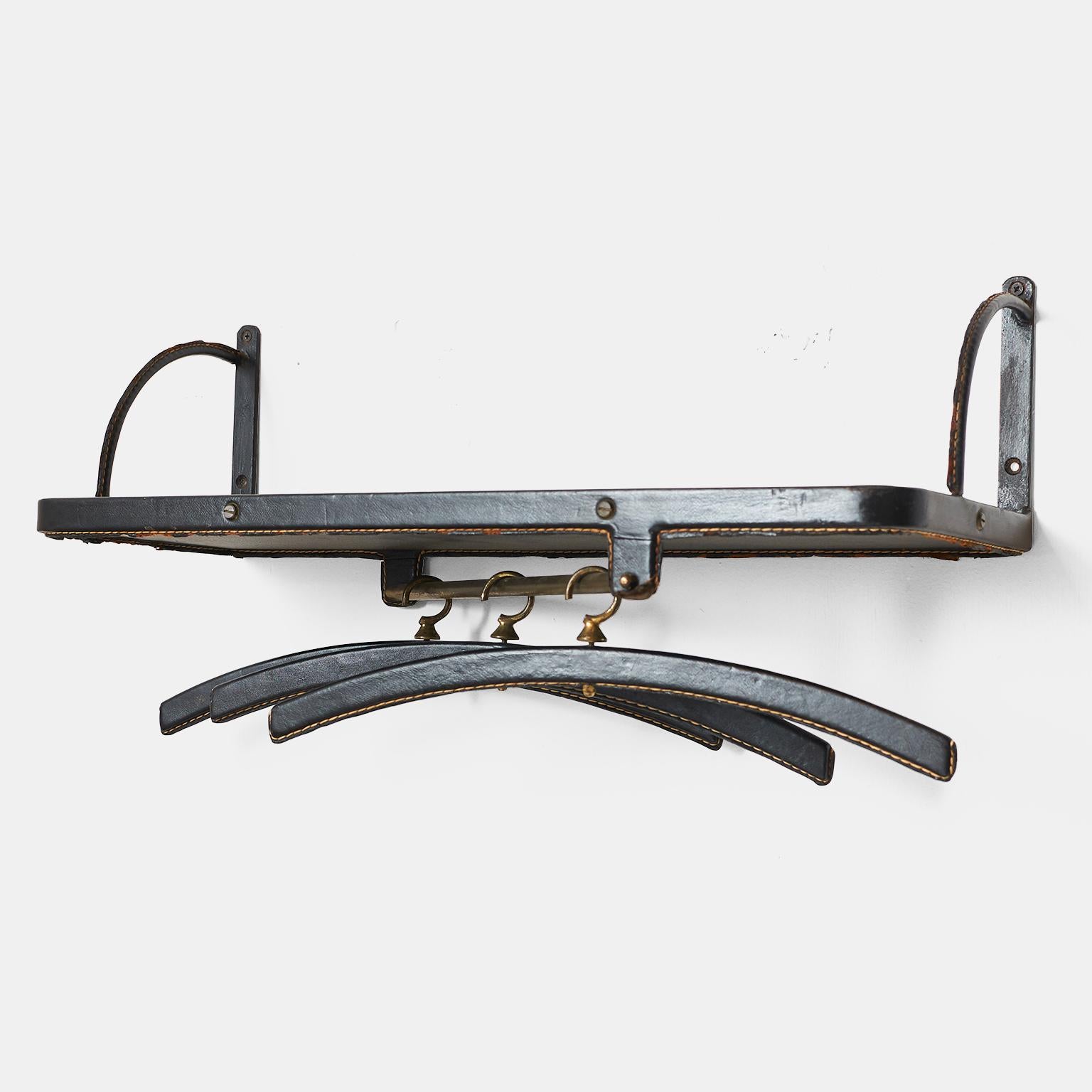 Wall mount coat rack by Jacques Adnet
A wall-mounted coat rack with iron bracket, stitched black leather covered shelf and three hangers with brass hooks.
France, circa 1950s.
  