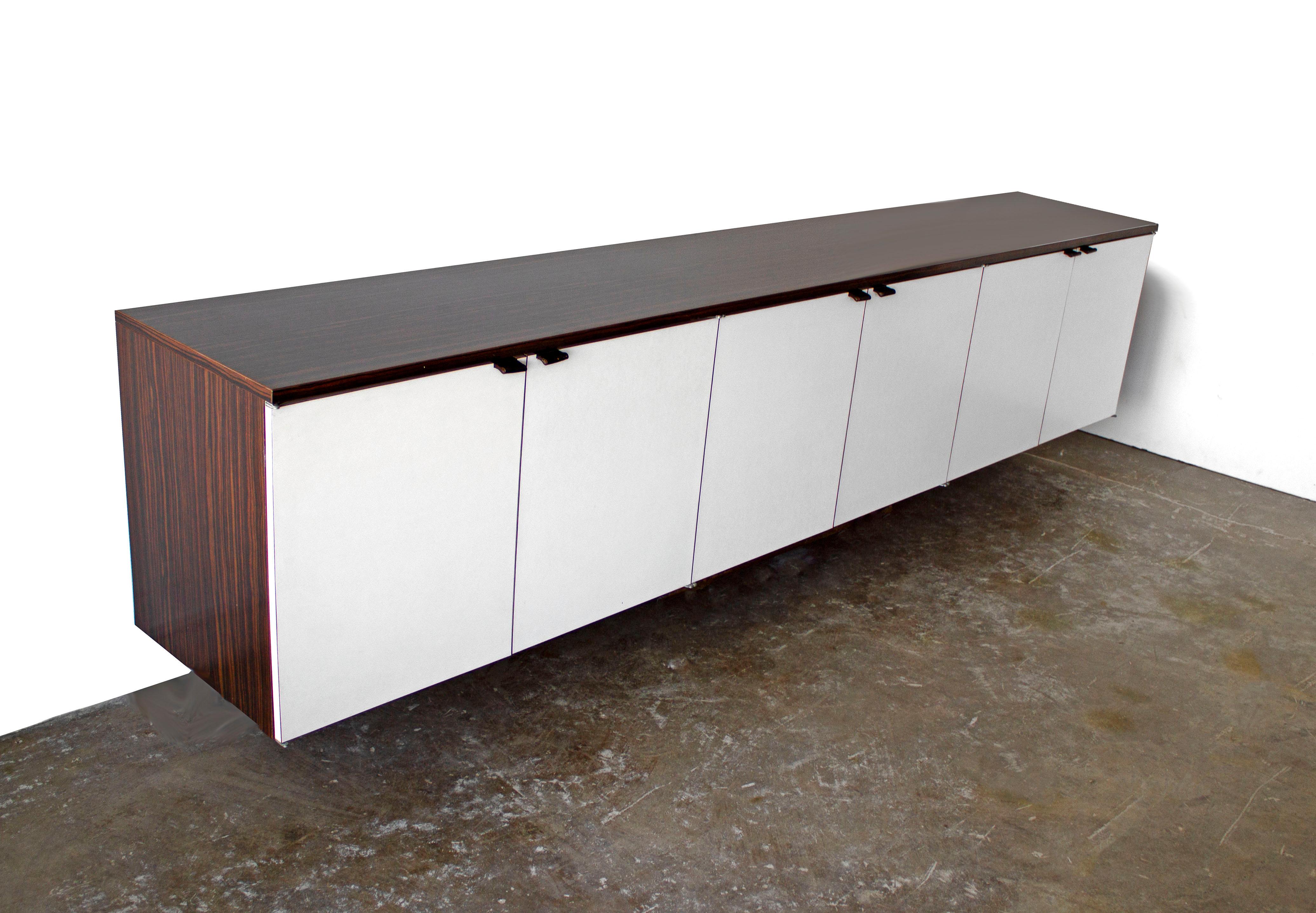 Custom-made wall mount credenza after Florence Knoll. The cabinet is an exotic rosewood laminate and the doors are white laminate. A large quality crafted piece with great style at an affordable price.