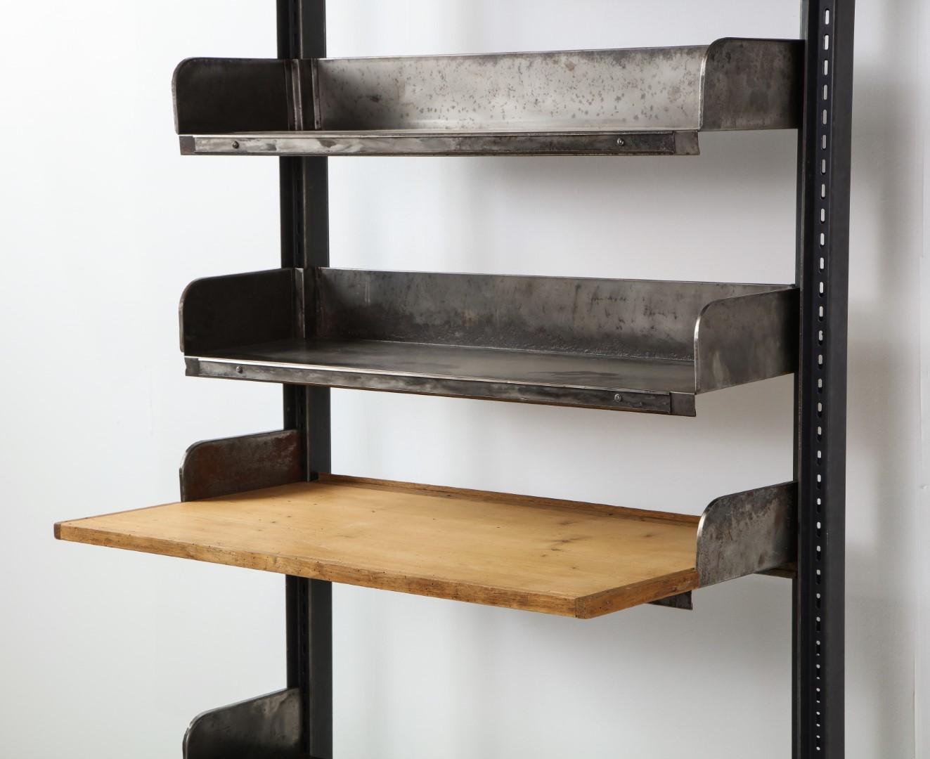1950s French midcentury industrial iron adjustable shelving system with wood desktop. Requires assembly. Provenance: Marché Paul Bert Serpette, Paris. 

Measures: Shelf depth 13.5