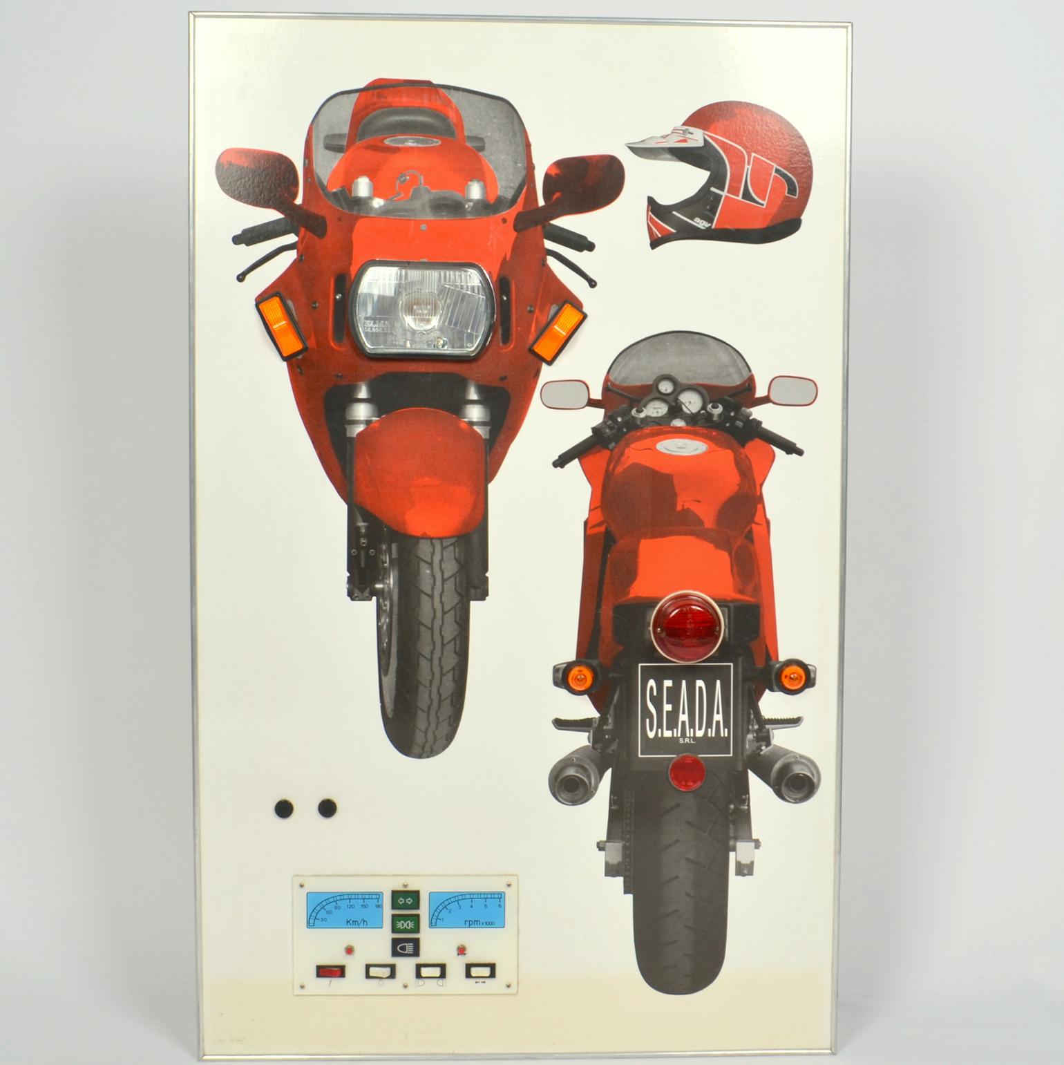 The wall mounted 1970s artwork demonstrating driving instructions about the use of motorbike lights. The manual instruction panel at the bottom can be used to switch on the various car lights and learn about the function of the operation of the