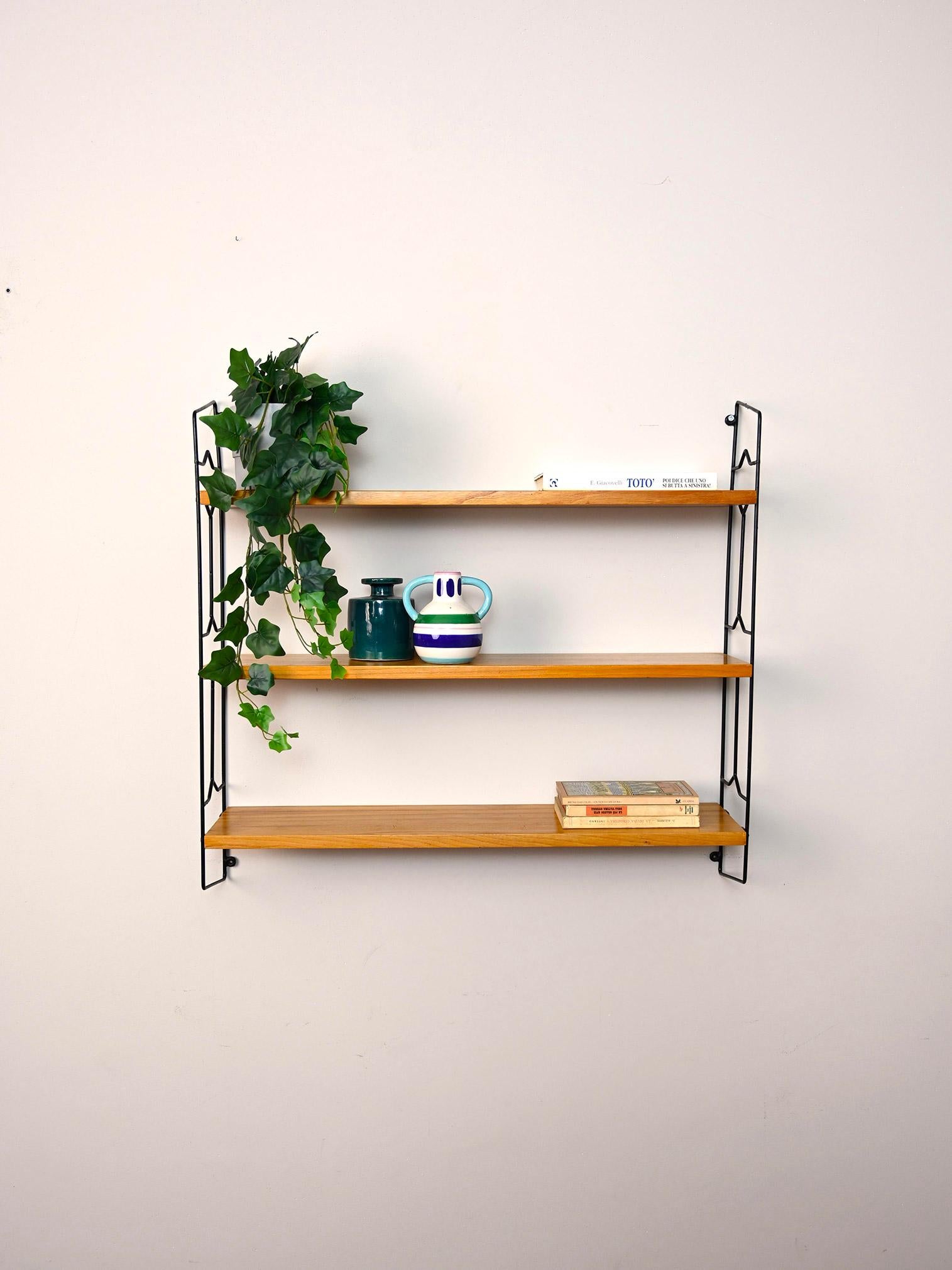Original Scandinavian shelves from the 1960s.

This simple shelving system consists of a black metal side frame on which three wooden shelves rest.
Simple and functional it can be hung in different rooms of the house.

Good condition. It has been