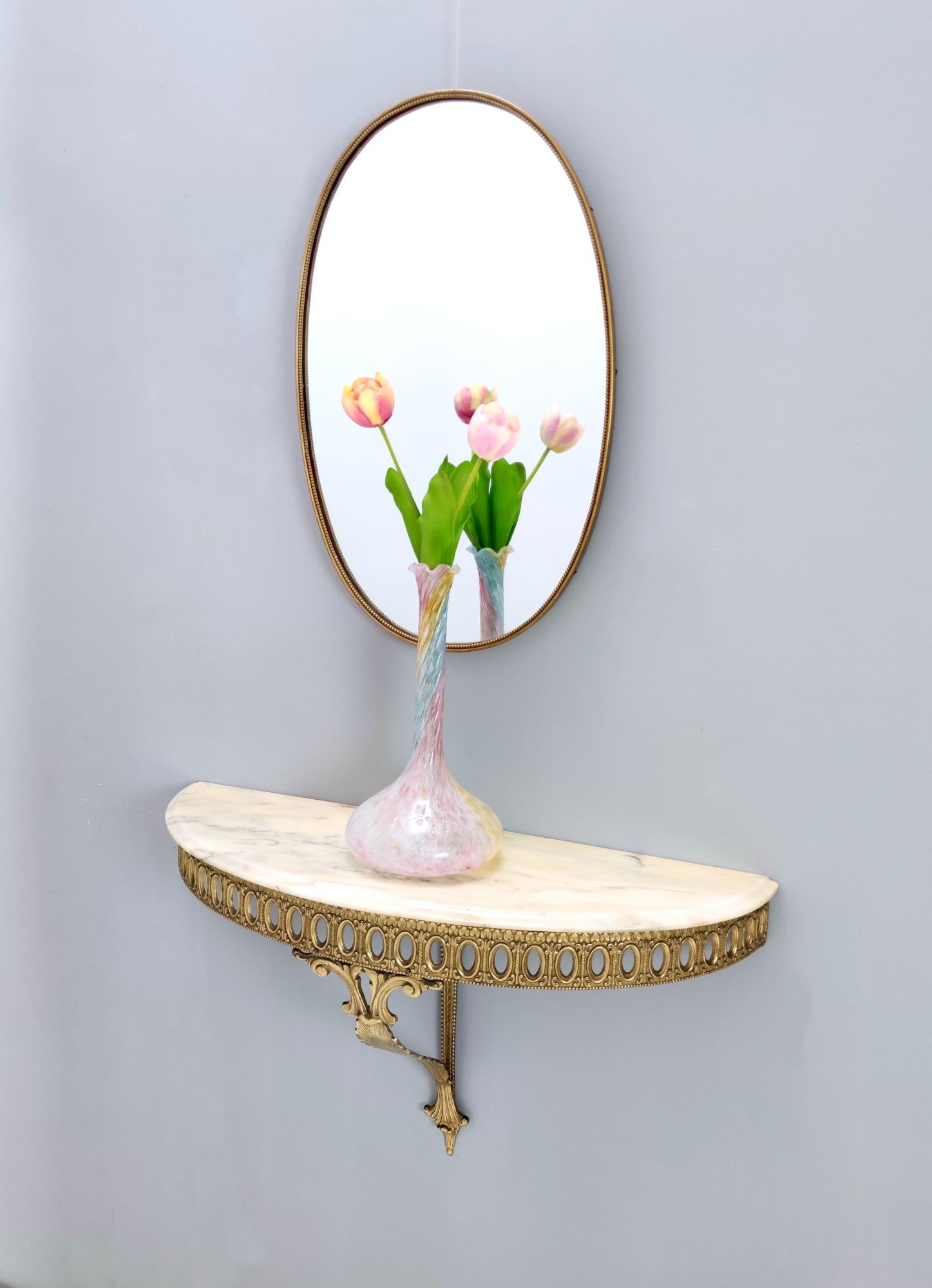 Italy, 1960s. 
This wall-mounted console table features a brass frame and a demilune Portuguese pink marble top. 
It might show slight traces of use since it's vintage, but it can be considered as in excellent original condition and ready to