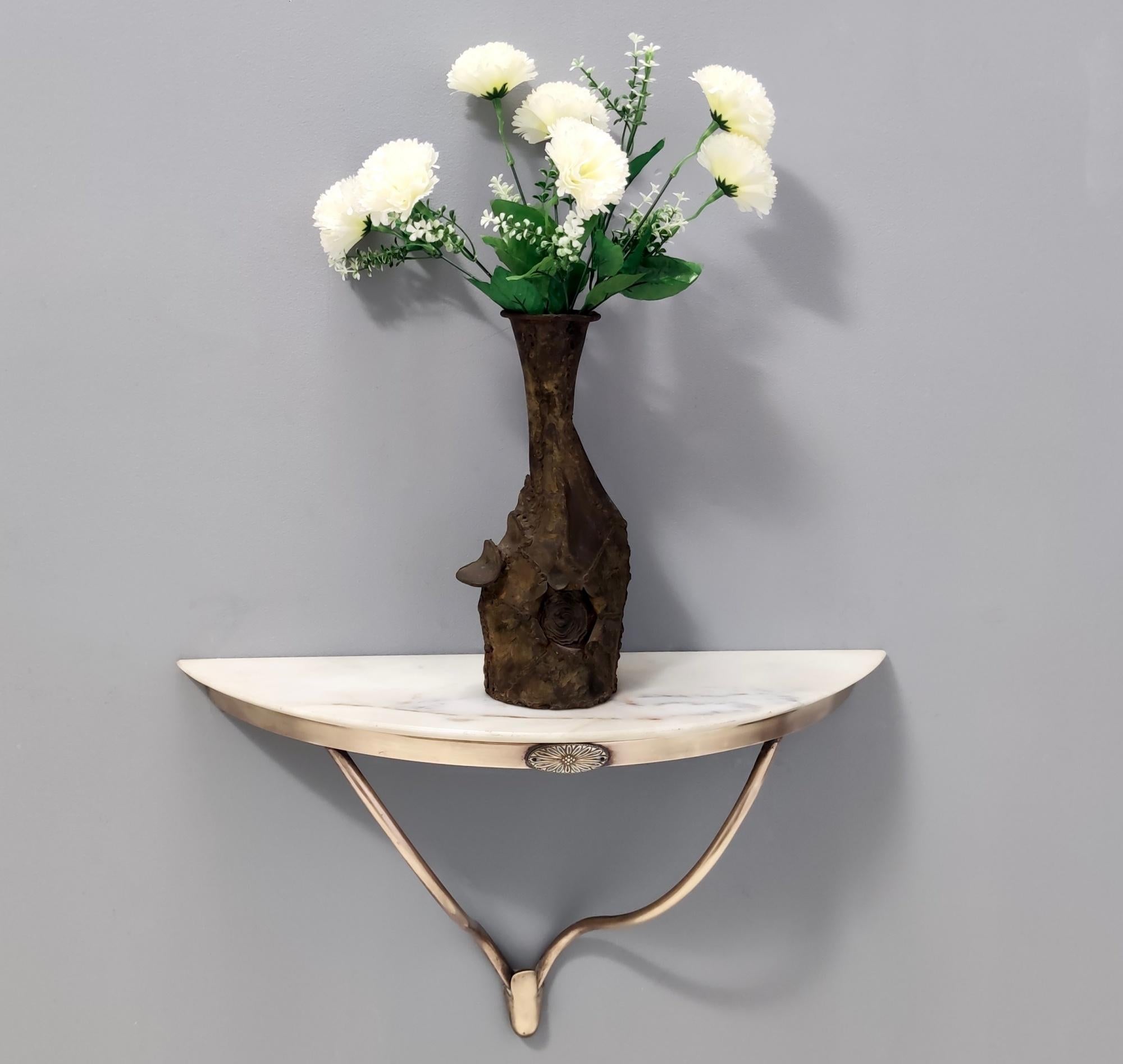 Italy, 1950s. 
This console table is in the style of Guglielmo Ulrich, and features a brass frame and a demilune Portuguese pink marble top. 
It might show slight traces of use since it's vintage, but it can be considered as in excellent original