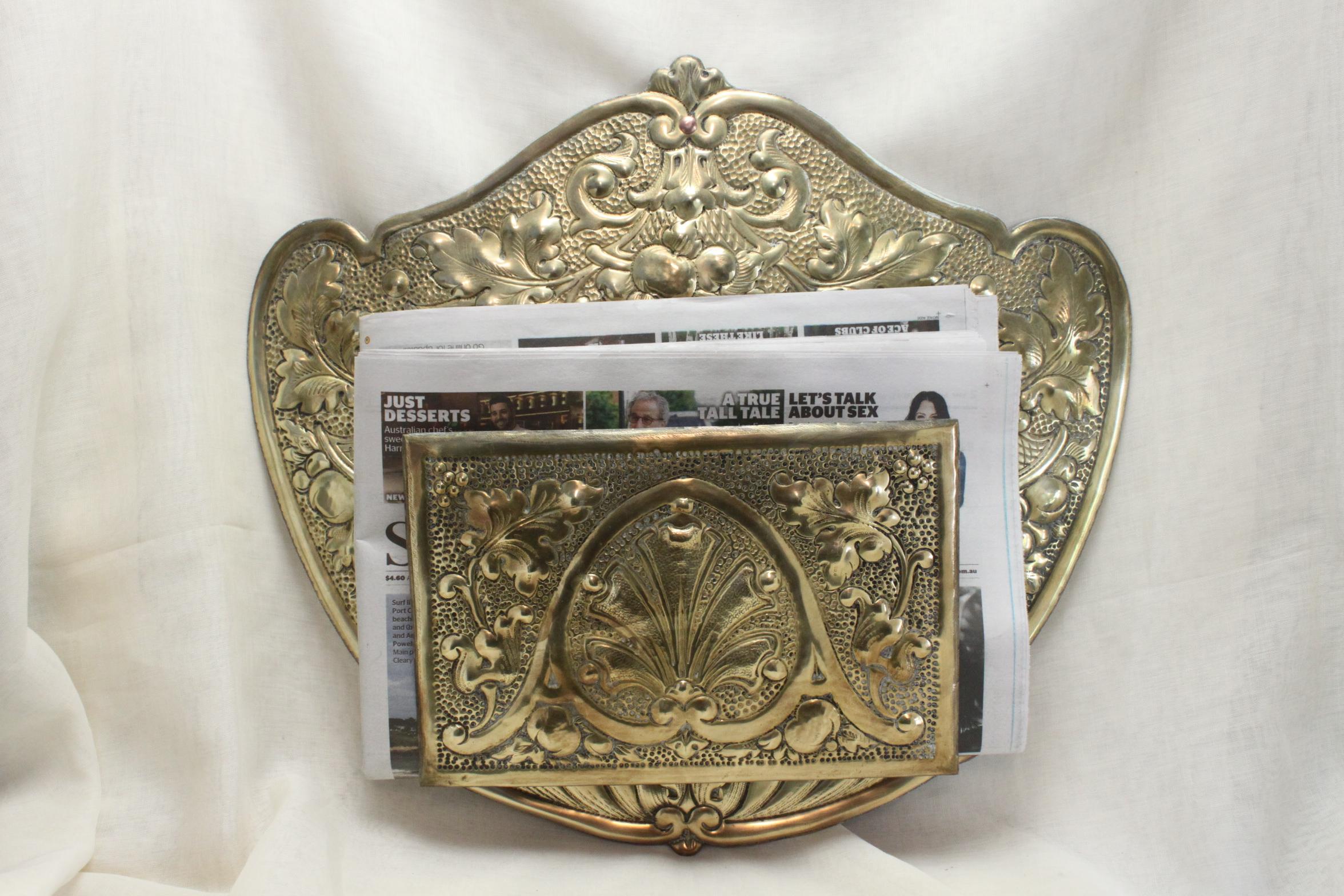 This eye catching pressed brass newspaper rack would have hung on a wall as a receptacle for newspapers or magazines. It could be used today for that purpose, left just as it is as wall decor or perhaps a double ended sheath of dried lavender or