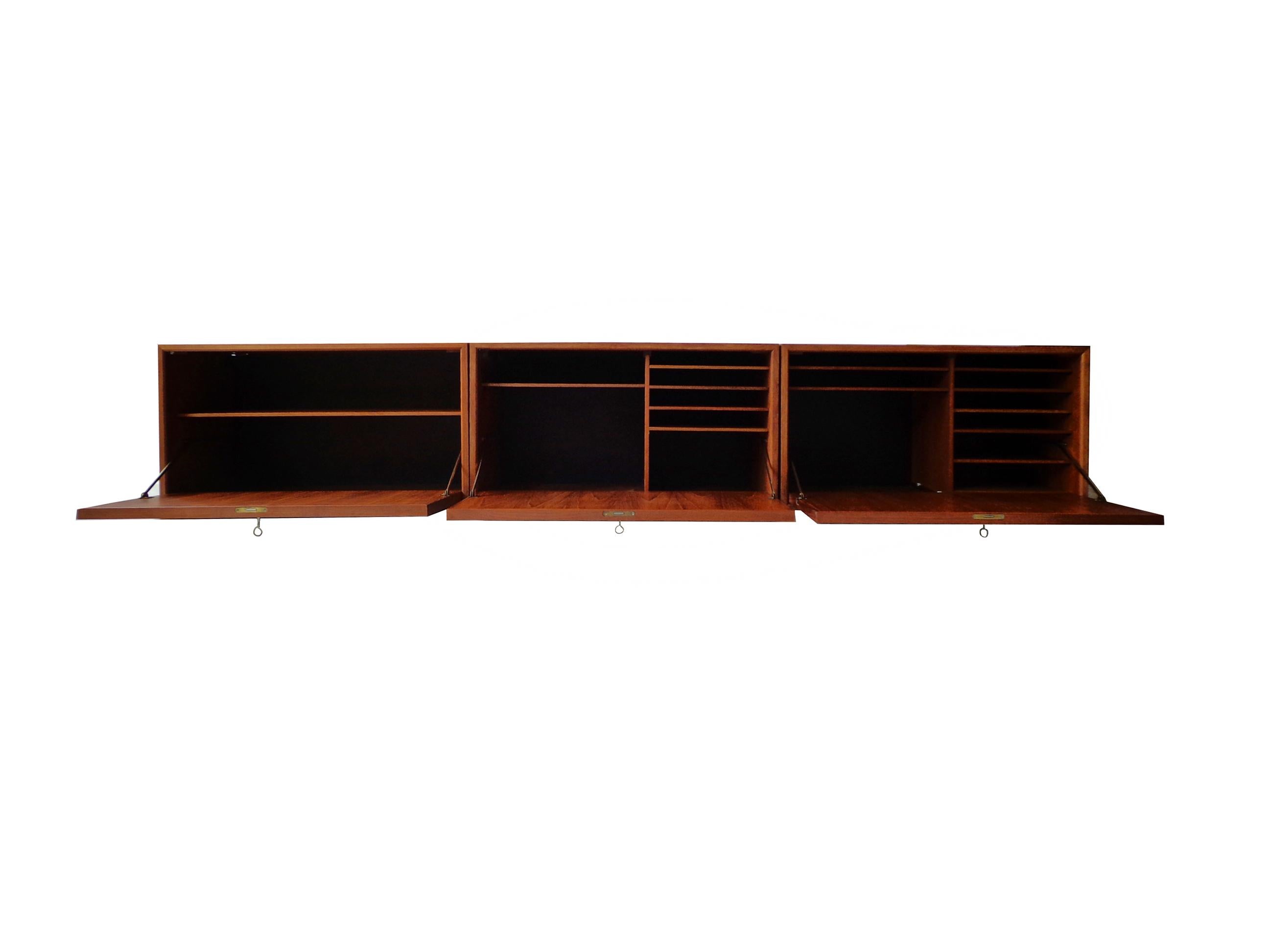 Wall-mounted cabinet of teak designed by Poul Cadovius, consisting three cabinets with door and shelves inside. Original keys included. Signed with paper makers plaquette.

Poul Cadovius created one of the world’s first wall-mounted shelving