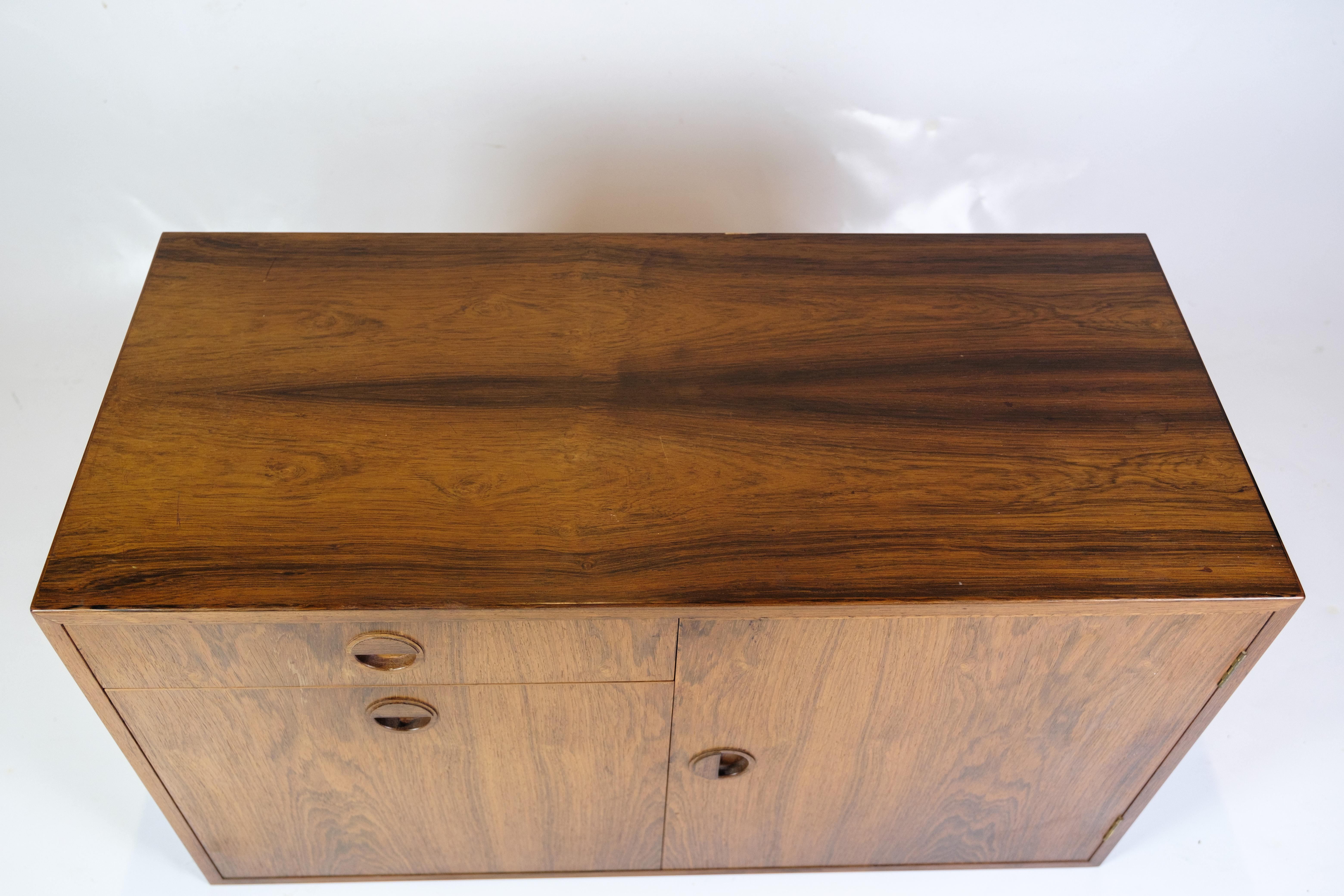 Wall-hung chest of drawers/cabinet in rosewood from the 1960s, of Danish design. The chest of drawers has a space-saving construction and is made of rosewood, which gives it an elegant appearance.
Dimensions: H:50cm W:89cm D:40cm