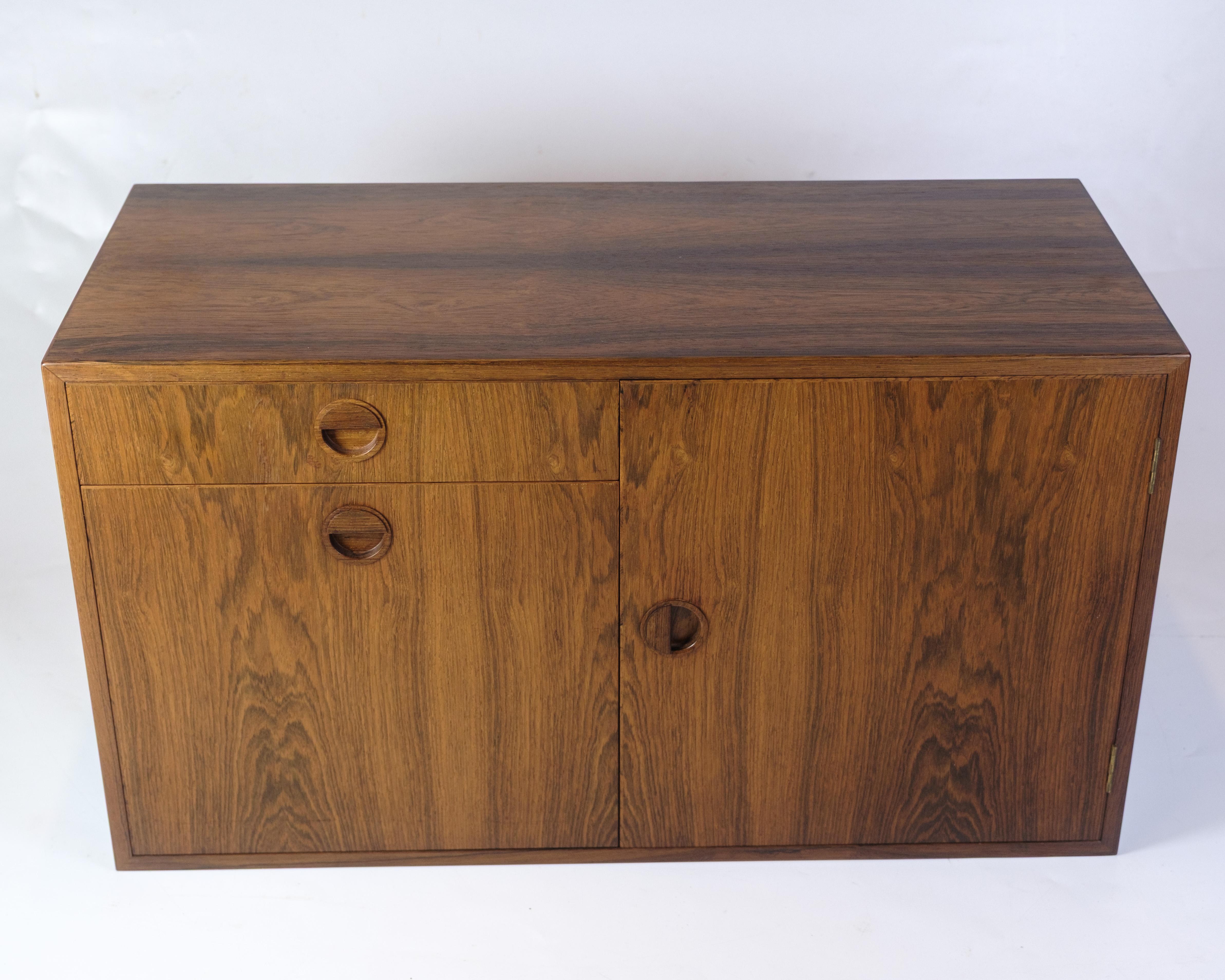 Wall-hung chest of drawers/cabinet in rosewood from the 1960s, of Danish design. The chest of drawers has a space-saving construction and is made of rosewood, which gives it an elegant appearance.

Dimensions: H:50cm W:89cm D:40cm