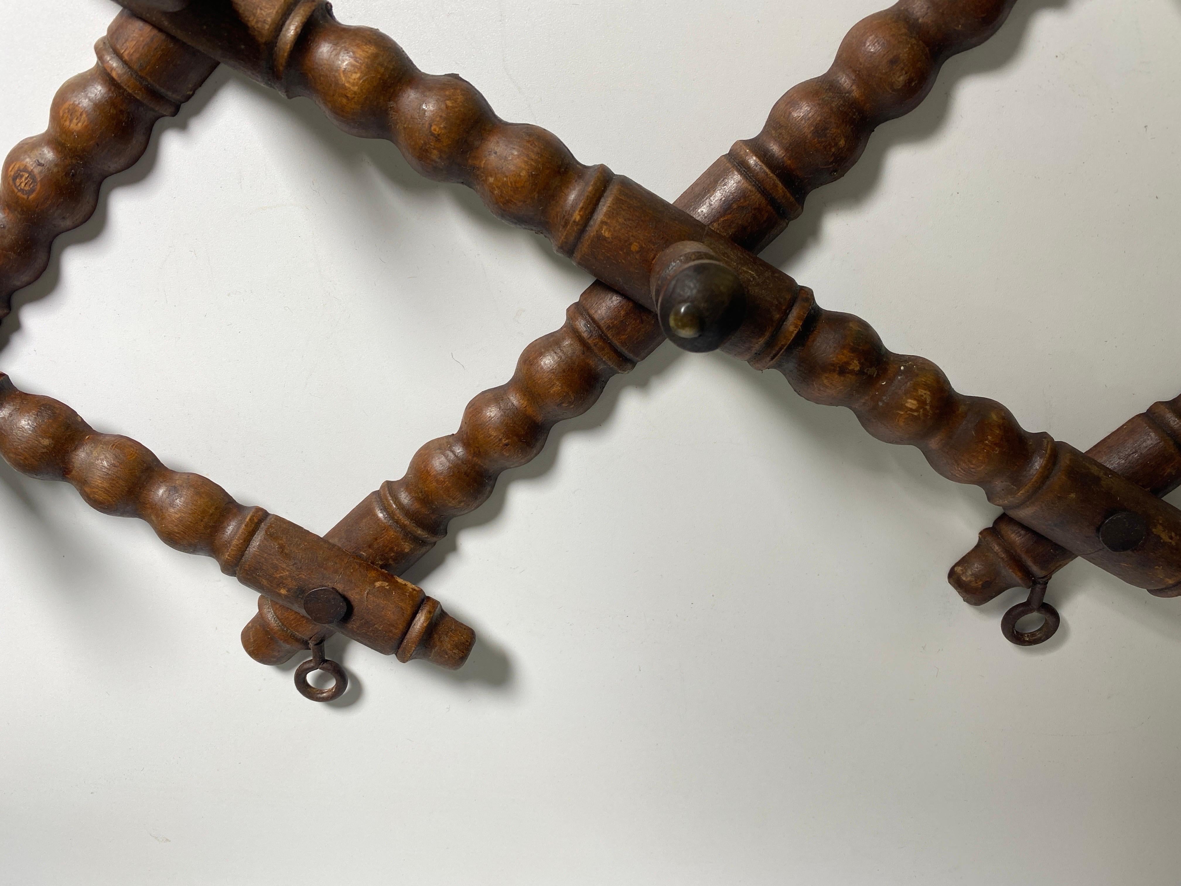 This coat rack is made of wood, brown in color. It was made in France around the 1950s. What is interesting is that it is foldable, and therefore its shape changes according to the degree you desire, so it can be horizontally extended or even more