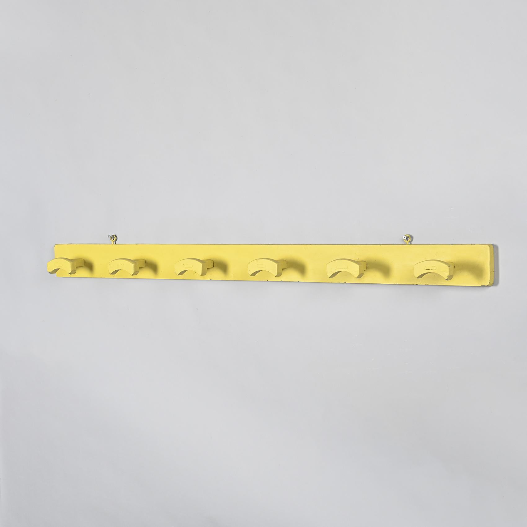 
Wall-mounted coat rack in yellow lacquered wood, anonymous work under the probable direction of Le Corbusier, circa 1952

It is composed of six massive wooden hooks, carved in a curved form and mounted on a rectangular wooden board, lacquered in