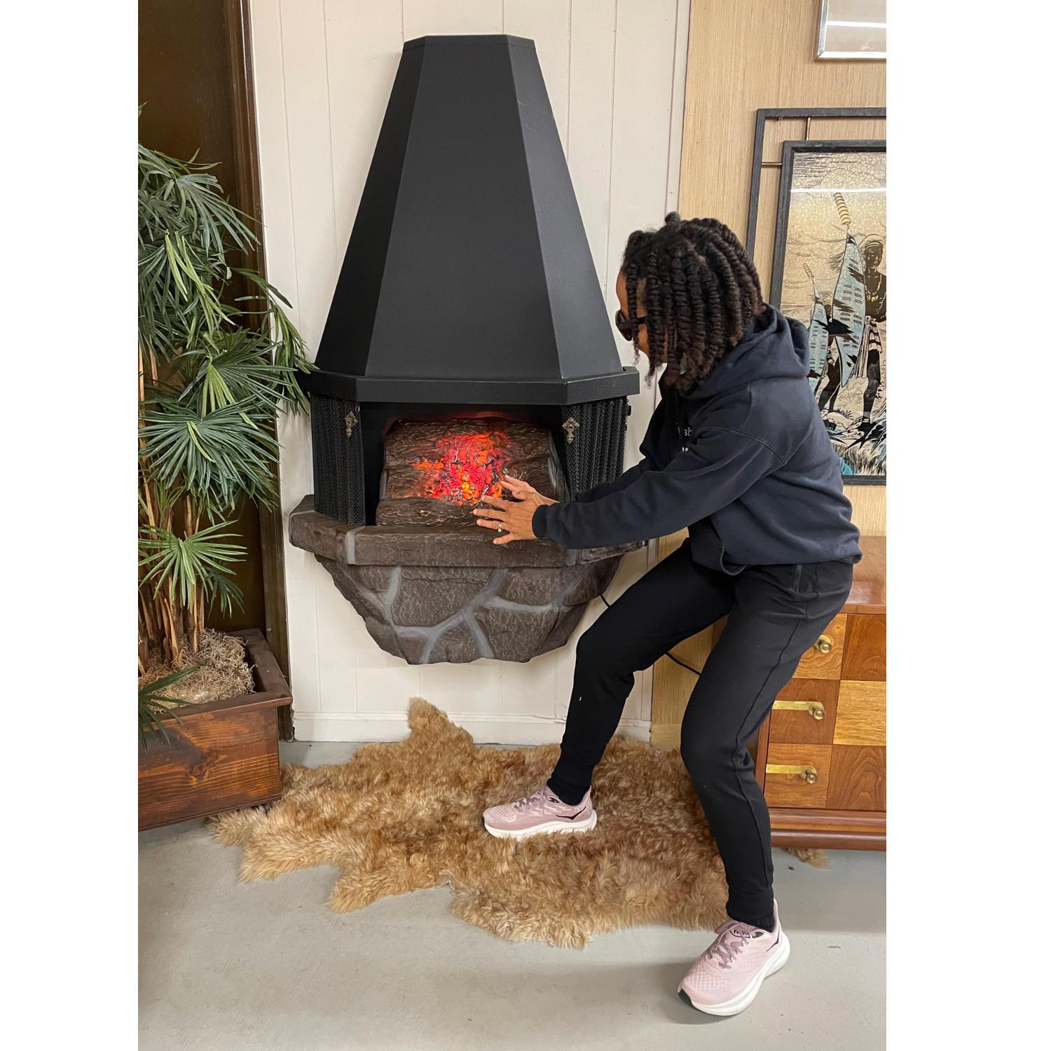 Mid-Century Modern era wall mounting electric fireplace complete with crackling logs. This charmer doesn’t just get by on it’s looks. It also has a space heater. There is a knob on the side to adjust the heat output. You can enjoy the lit logs with