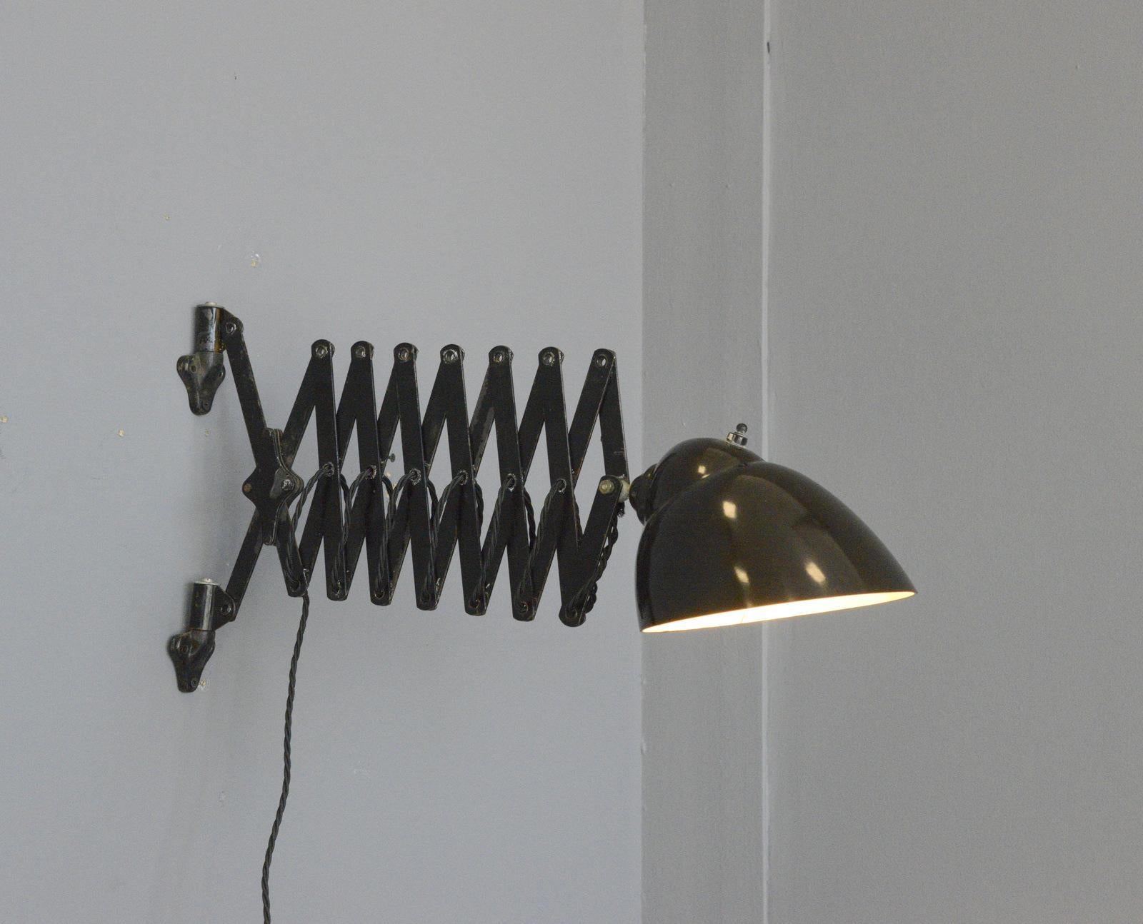 Wall mounted German scissor lamp, circa 1920s

- Bakelite shade
- Cast iron feet
- Extendable scissor mechanism
- Takes E27 fitting bulbs
- German, 1920s
- Measures: 18cm wide x 30cm tall
- Extends up to 90cm from the wall

Condition