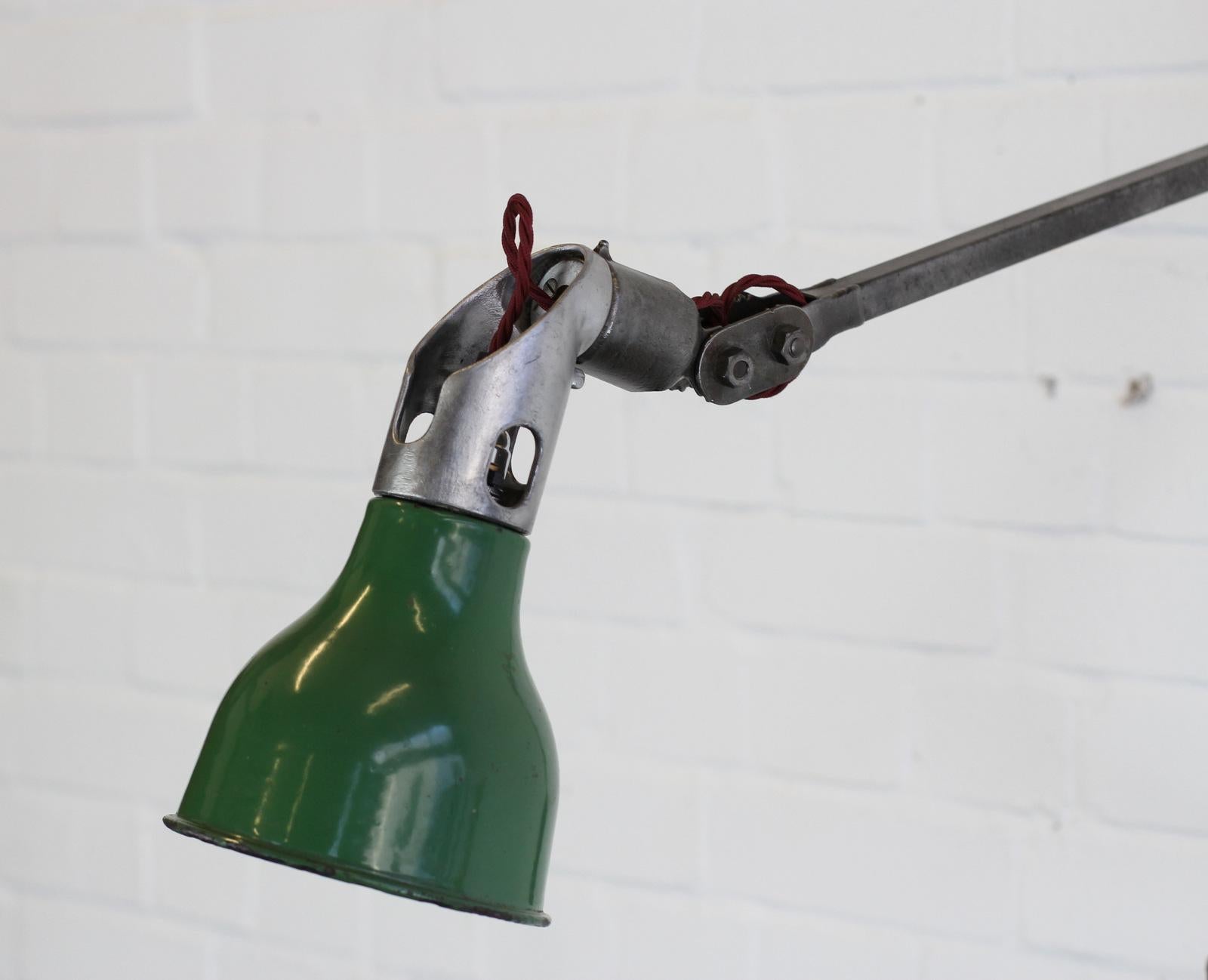 Wall mounted industrial task lamp by Mek Elek, circa 1930s.

- Vitreous green enamel shade
- Articulated brushed steel arms
- Inline on/off switch on the head of the lamp
- Embossed makers mark on the head
- Takes B22 fitting bulbs
- English,