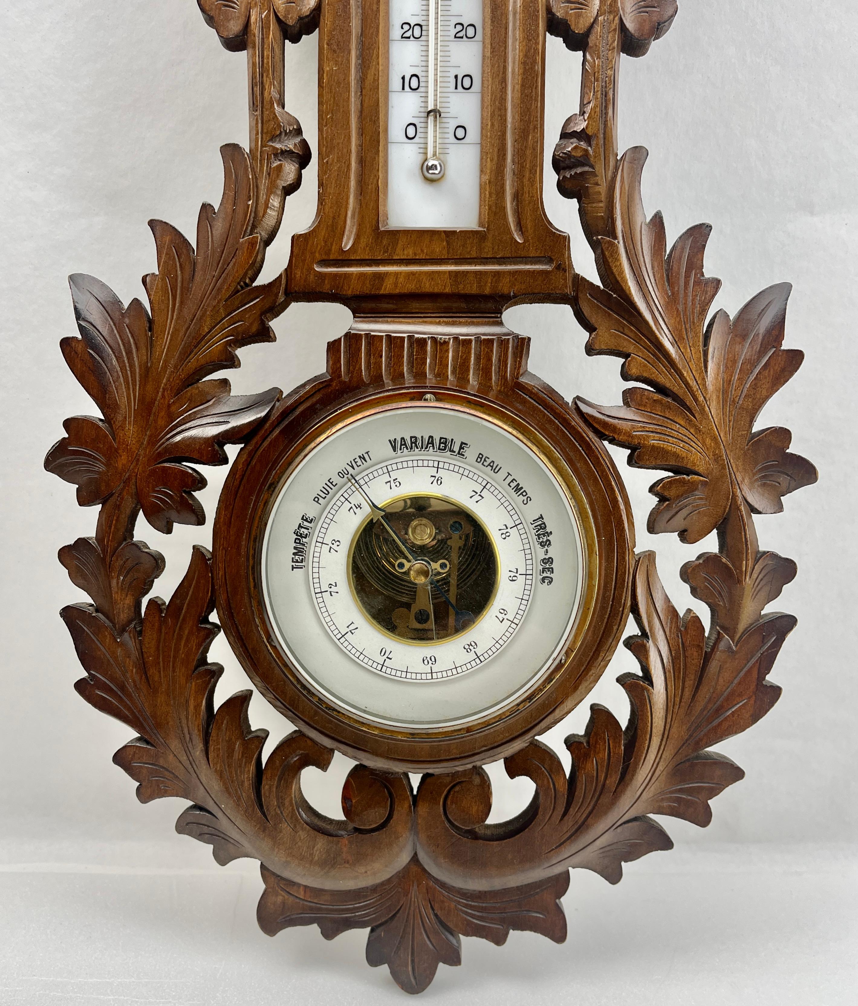 Station météo murale en noyer sculpté fabriquée à Liège en Belgique par G.Tart. 
Mécanisme de haute qualité avec mouvement Jewell baromètre et thermomètre (en centigrades)
Motif inhabituel de volutes et de fleurs en haut-relief dans le style rococo