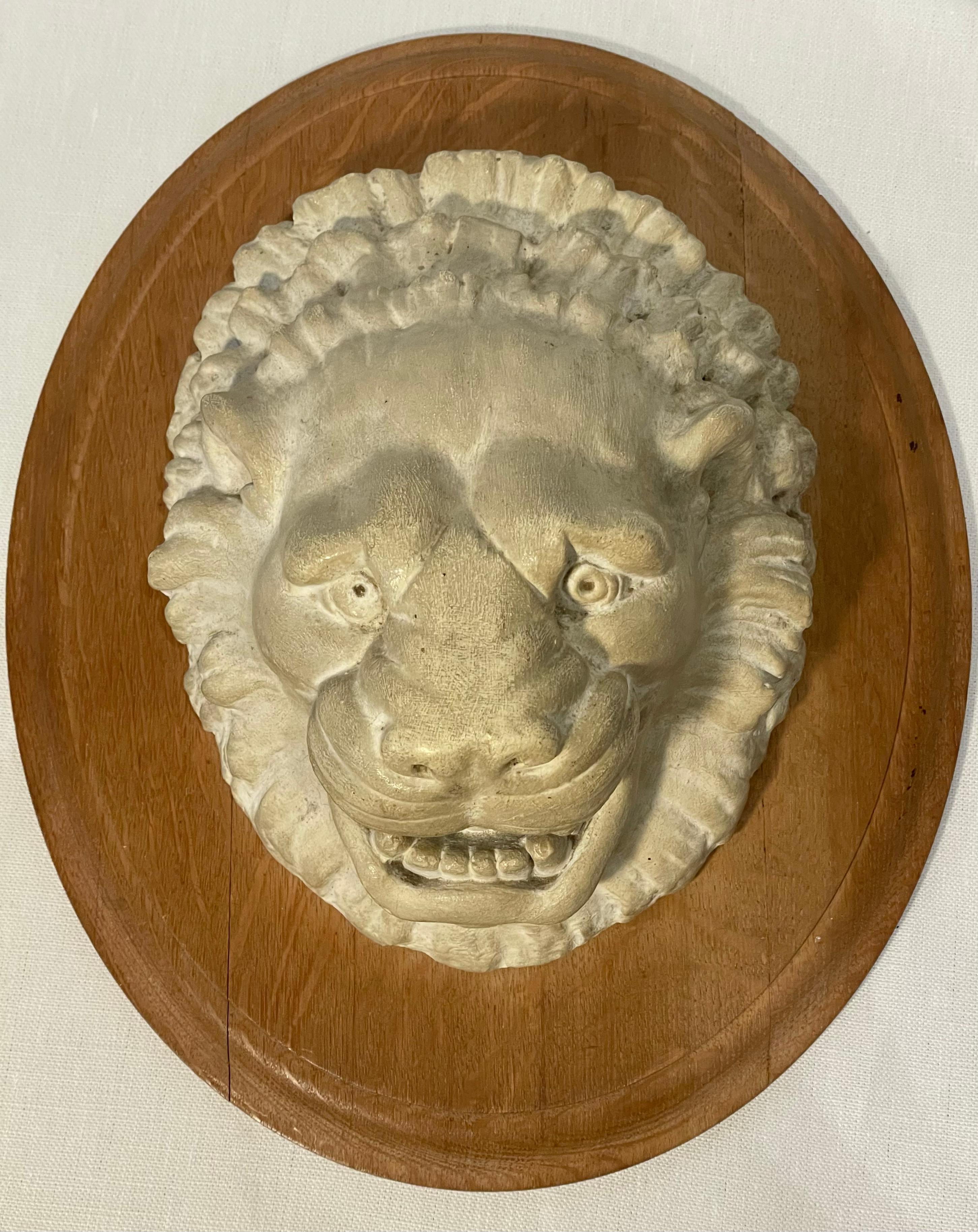 19th-century plaster molded lion head mounted on an oak plaque. English, circa 1890.