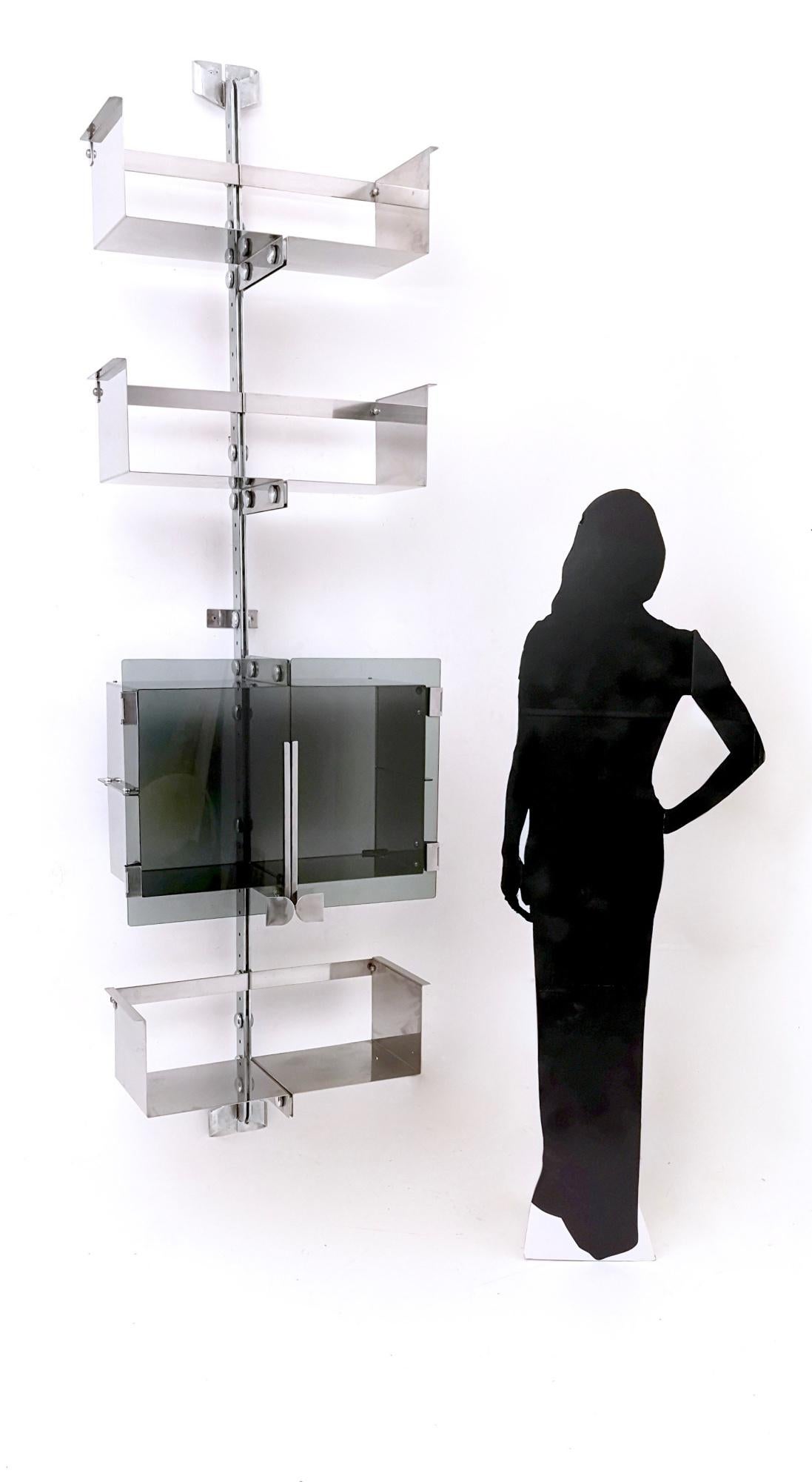 This is an extraordinary four-shelf stainless steel shelving unit by Vittorio Introini for Saporiti, 1969. 
It is a rare item since it features tempered glass doors for one shelf. 
In the ninth picture it is possible to see the sign of glass