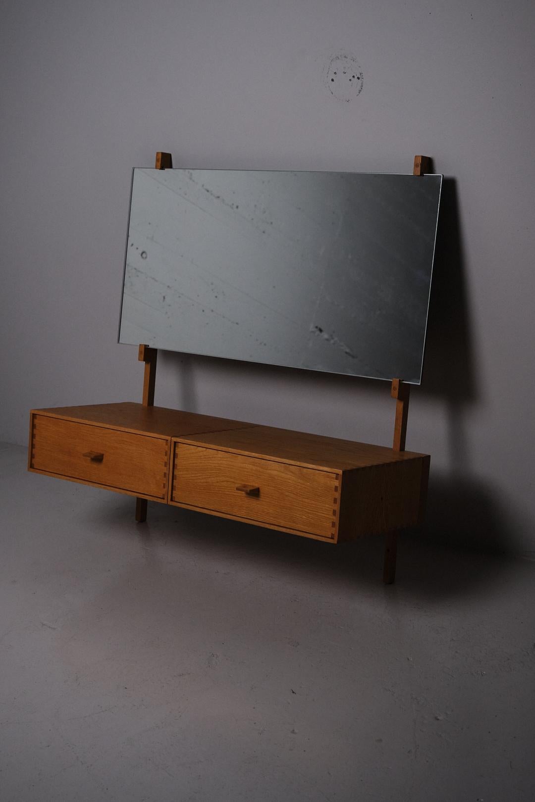Magnifique coiffeuse murale moderne du milieu du siècle dernier par Uno et Östen Kristiansson, produite par Luxus Vittsjö, Suède, dans les années 1960. 

Fabriqué en chêne avec de grands détails dans la menuiserie, des poignées sculptées sur les