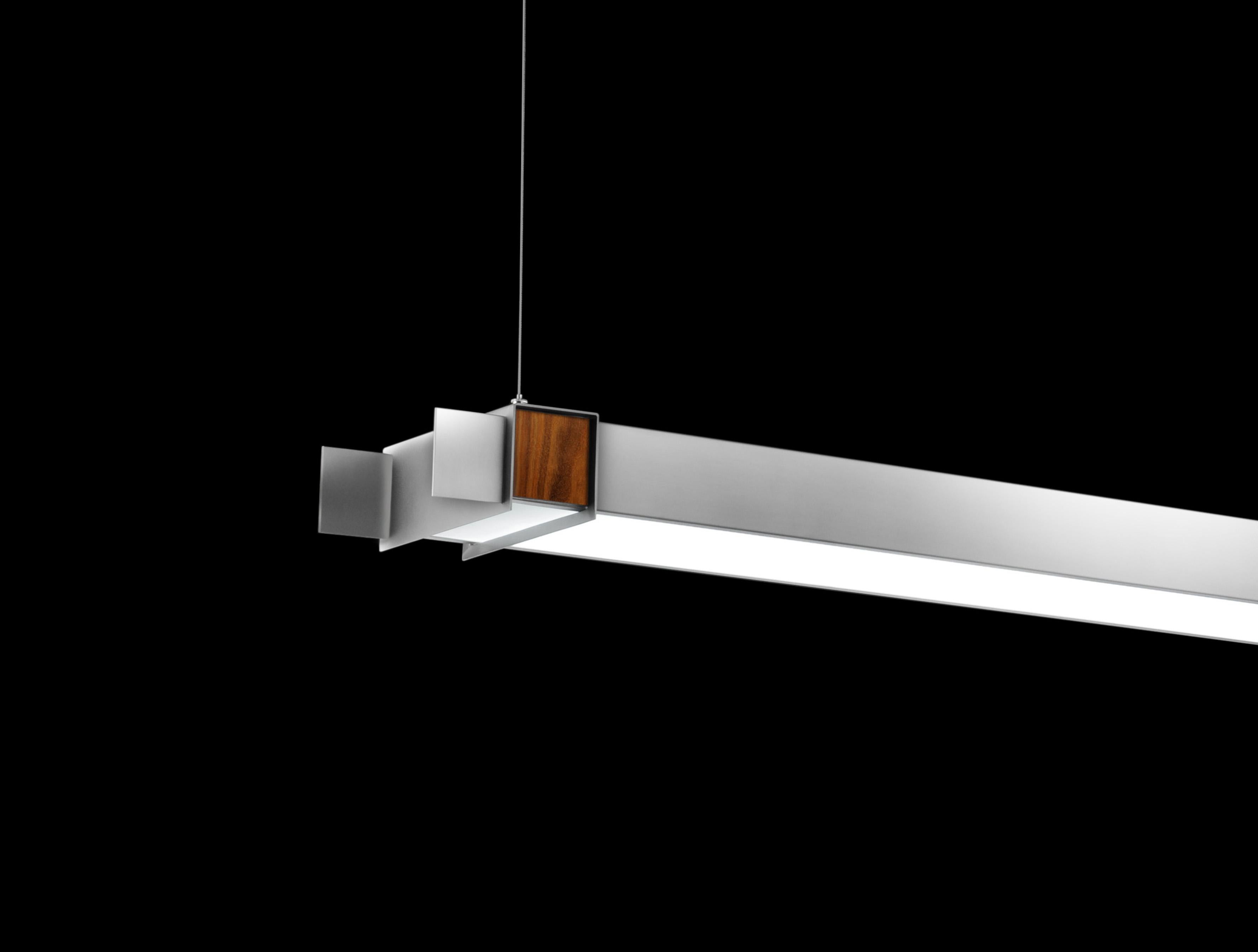 Unique wall-mounted pendant with white glass bottom diffuser in a painted silver steel housing. Inset wood details. In the manner of Mid-Century Modern. LED Lamped, 3000k standard color temperature. Great for use in pairs.

Architect, Sandy