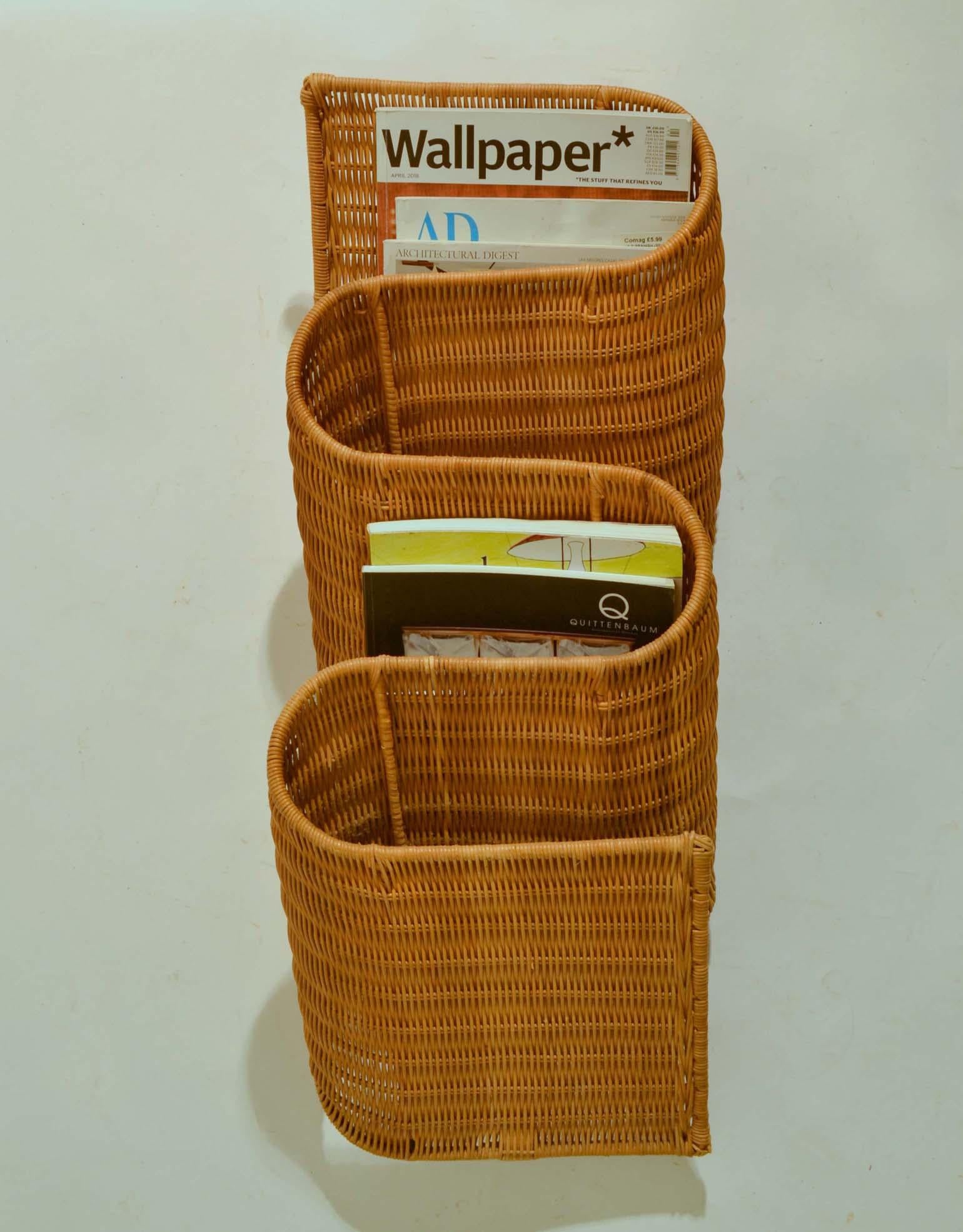Wall mounted rattan hand woven magazine holders, very efficient and decorative, the way it snakes along the wall. It has 4 sections for magazines. And is made in Italy, 1960s-1970s.