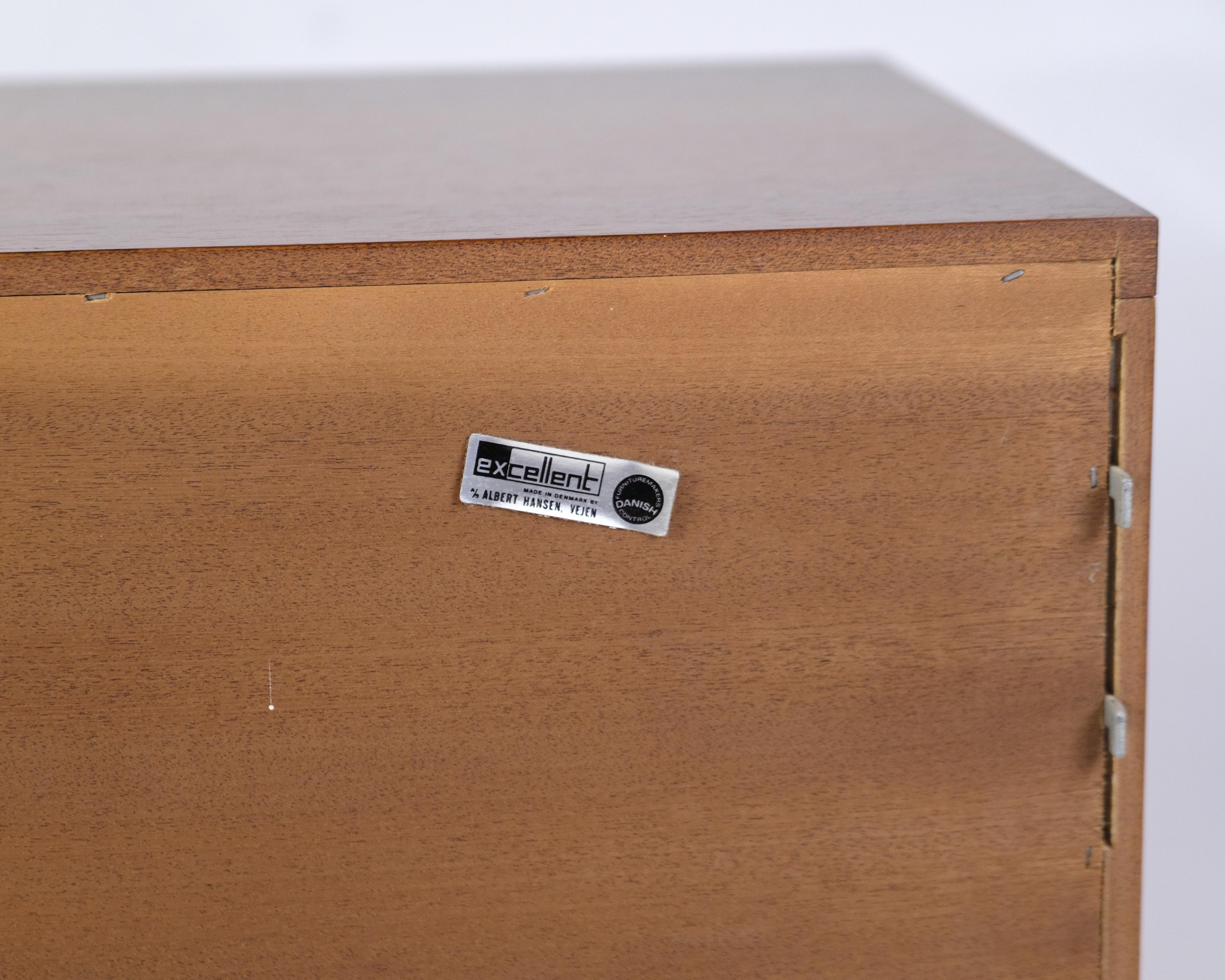 wall-mounted cabinet in rosewood, designed by Albert Hansen in the 1960s under the name Model Excellent. The clean lines and floating suspension combined with the rosewood's vibrant grain patterns give an elegant and functional expression. A typical