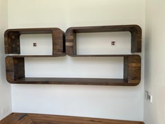 Wall mounted shelving unit in solid walnut by Jonathan Field