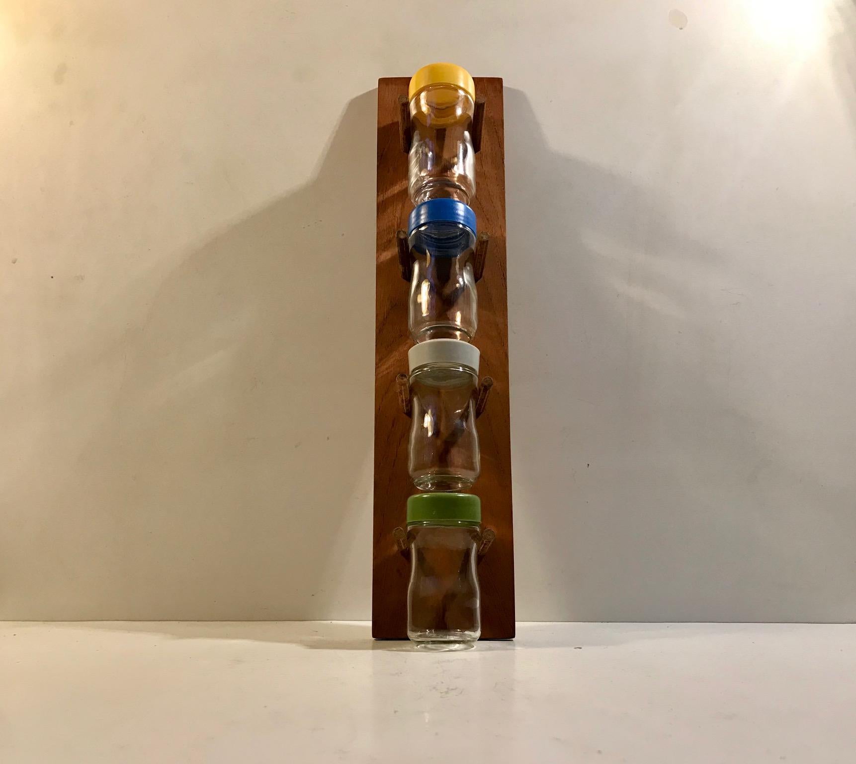 Practical wall unit that consist of a wall rack in teak and 4 spice glasses. 3 with sprinkle holes and one without. Designed and manufactured by Lüthje in Denmark during the 1960s.