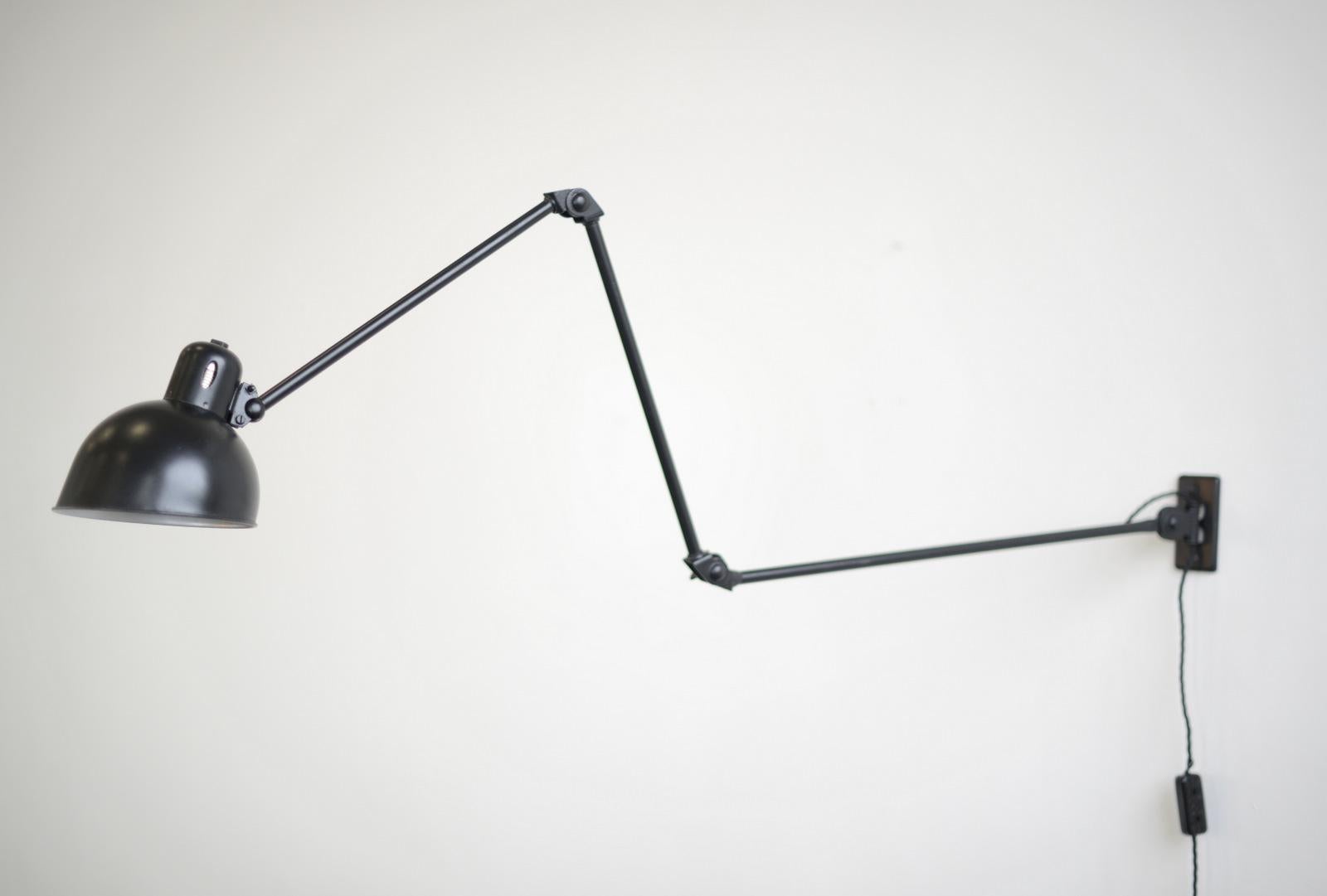 wall-mounted task lamp by Christian Dell For Karanda 

- Adjustable arms and shade
- Inline switch on the cord
- Takes E27 fitting bulbs
- Designed by Christian Dell for Karanda
- Austrian ~ 1920s
- Shade measures 16cm wide 
- Extends up to
