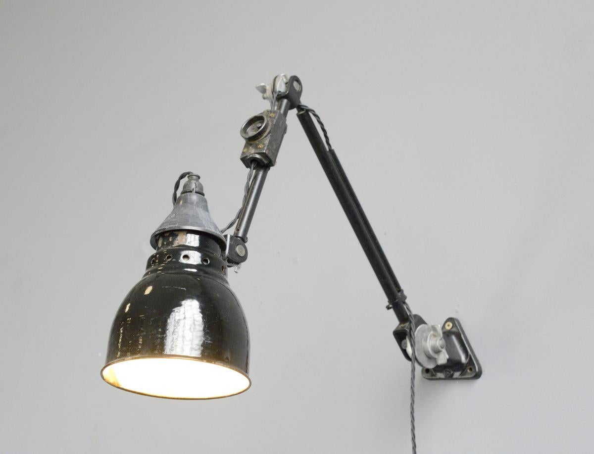 Wall-mounted task lamp by Rademacher, circa 1920s

- Vitreous black enamel shade
- Bakelite switch
- Takes E27 fitting bulbs
- Tubular steel articulated arms
- By Ernst Rademacher
- German, 1920s
- Shade measures 13 cm wide 
- Extends up to