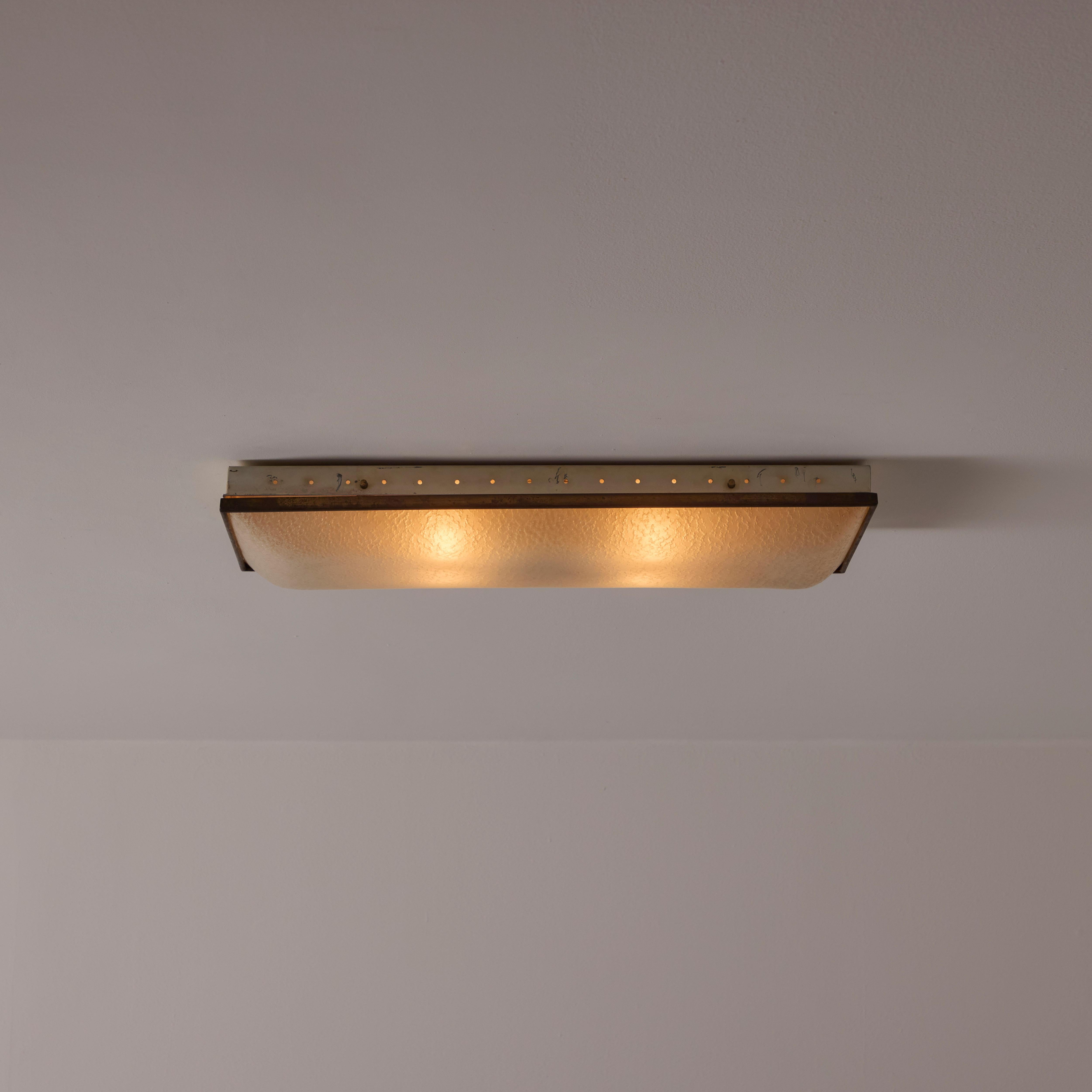 Flushmount by Fontana Arte. Designed and manufactured in Italy, circa the 1950s. Textured panel glass paired with an enameled housing and brass accents. The light holds four E27 socket types, adapted for the US. Rewired for the US. We recommend four