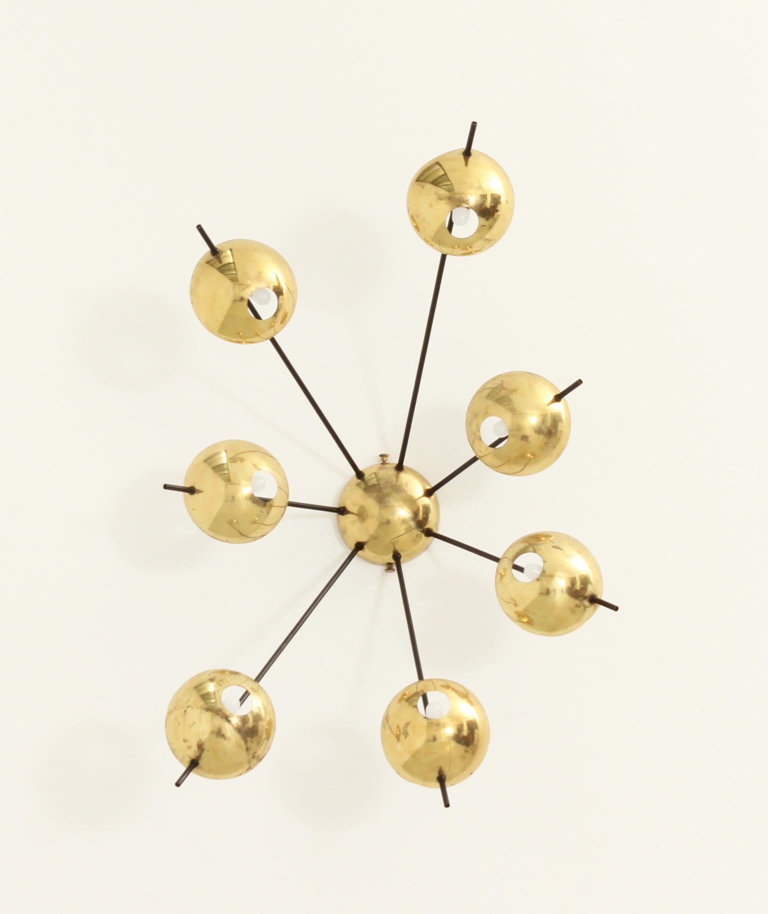 Wall or ceiling sconce model 2055/7 edited by Stilnovo, Italy, 1950's. Seven arms with brass shades. Brass and black enamelled metal arms.