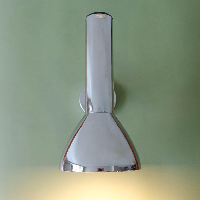 This wall sconce, model 3001, was designed and produced by Fase, in Spain, in 1974. It is made of chromed metal and it has a rotating spotlight, that can be moved in different directions. With two original labels of the manufacture, one sticked on