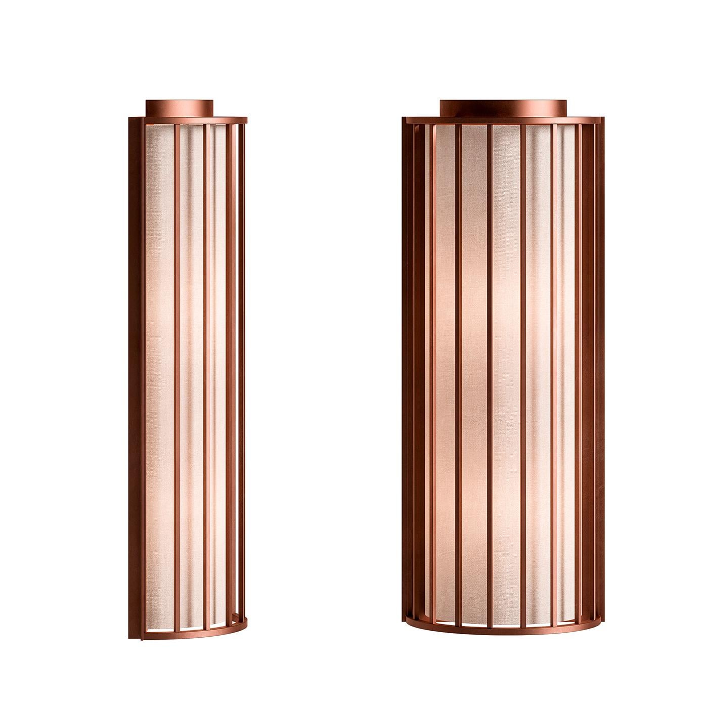 Old and new blend seamlessly together in this remarkable wall sconce that showcases a sculptural profile reminiscent of old lanterns. Marked by a cage-style cylindrical frame, this sconce is crafted of metal with a brushed-copper finish that