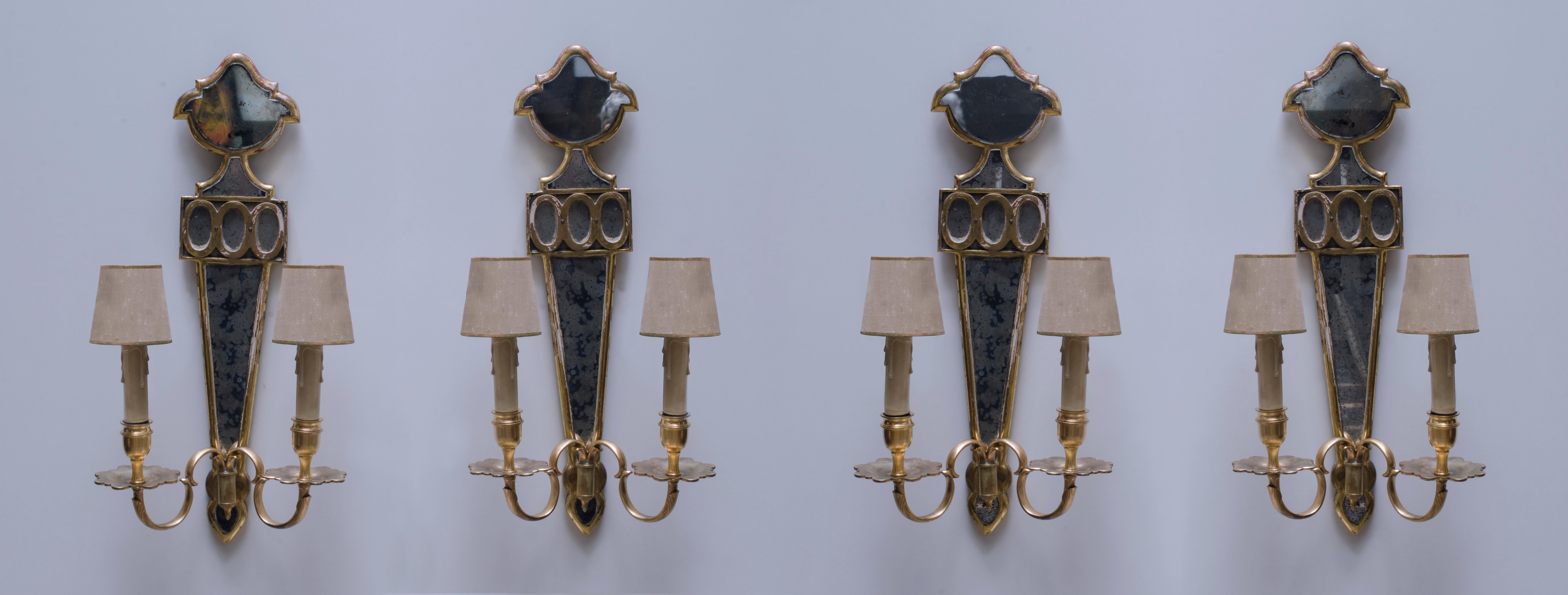 Wall sconces made by Maison Jansen. Made with a wooden structure with gilt leaf, Venetian mirror and bronze arms with wooden veins.

France, CIRCA 1940.
