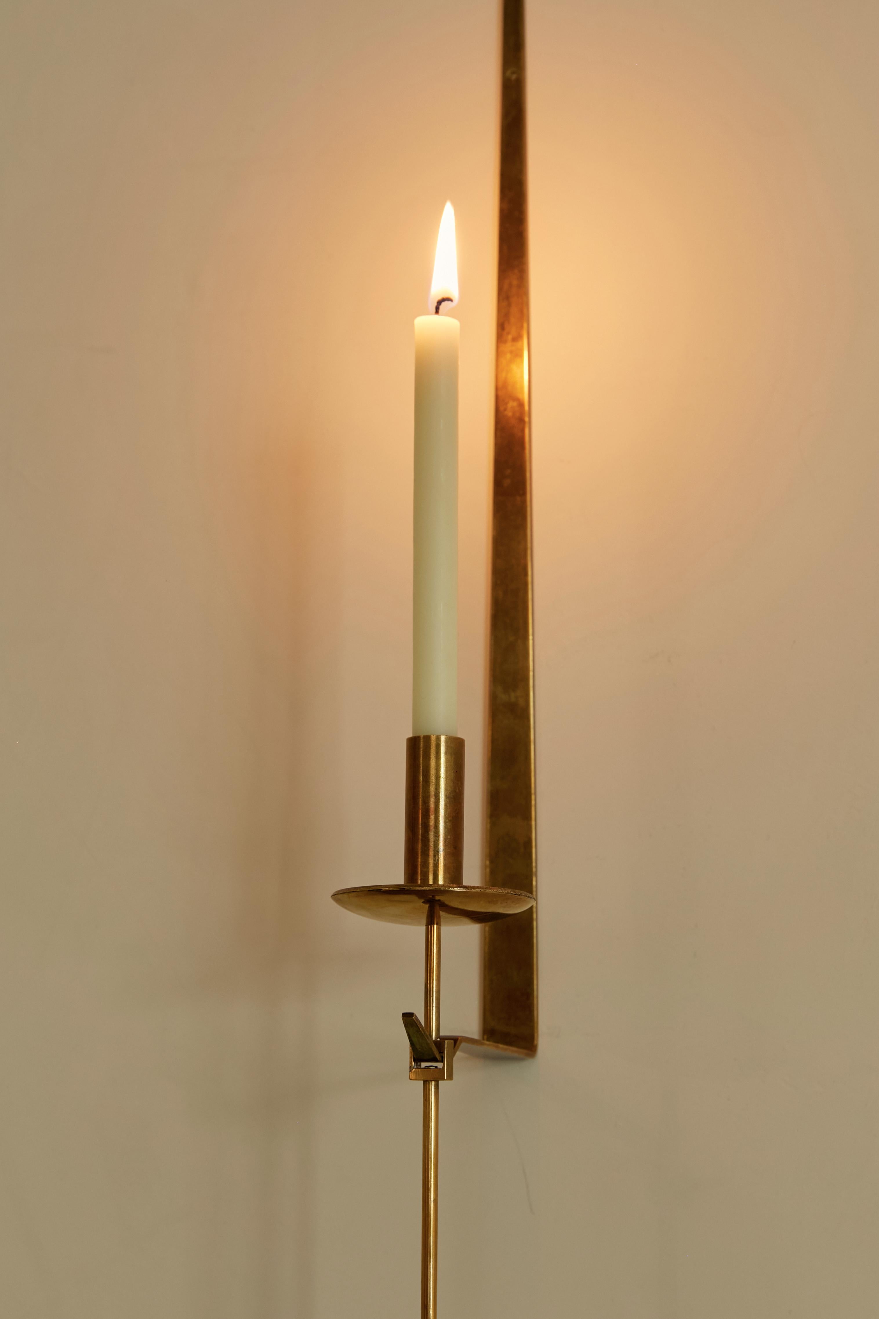 Wall candleholder in pendulum shape. Brass material, lightweight. For normal long shaped candles.