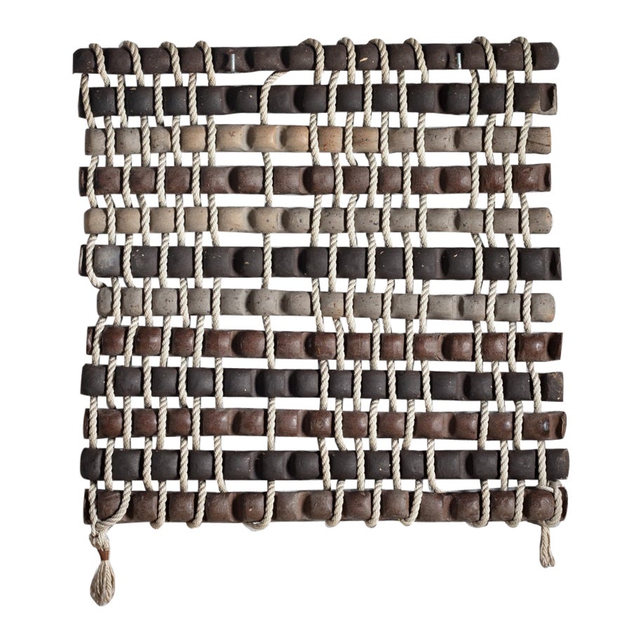 Scultura da parete intitolata "Tressage tubulaire" in gres grigio, marrone e nero