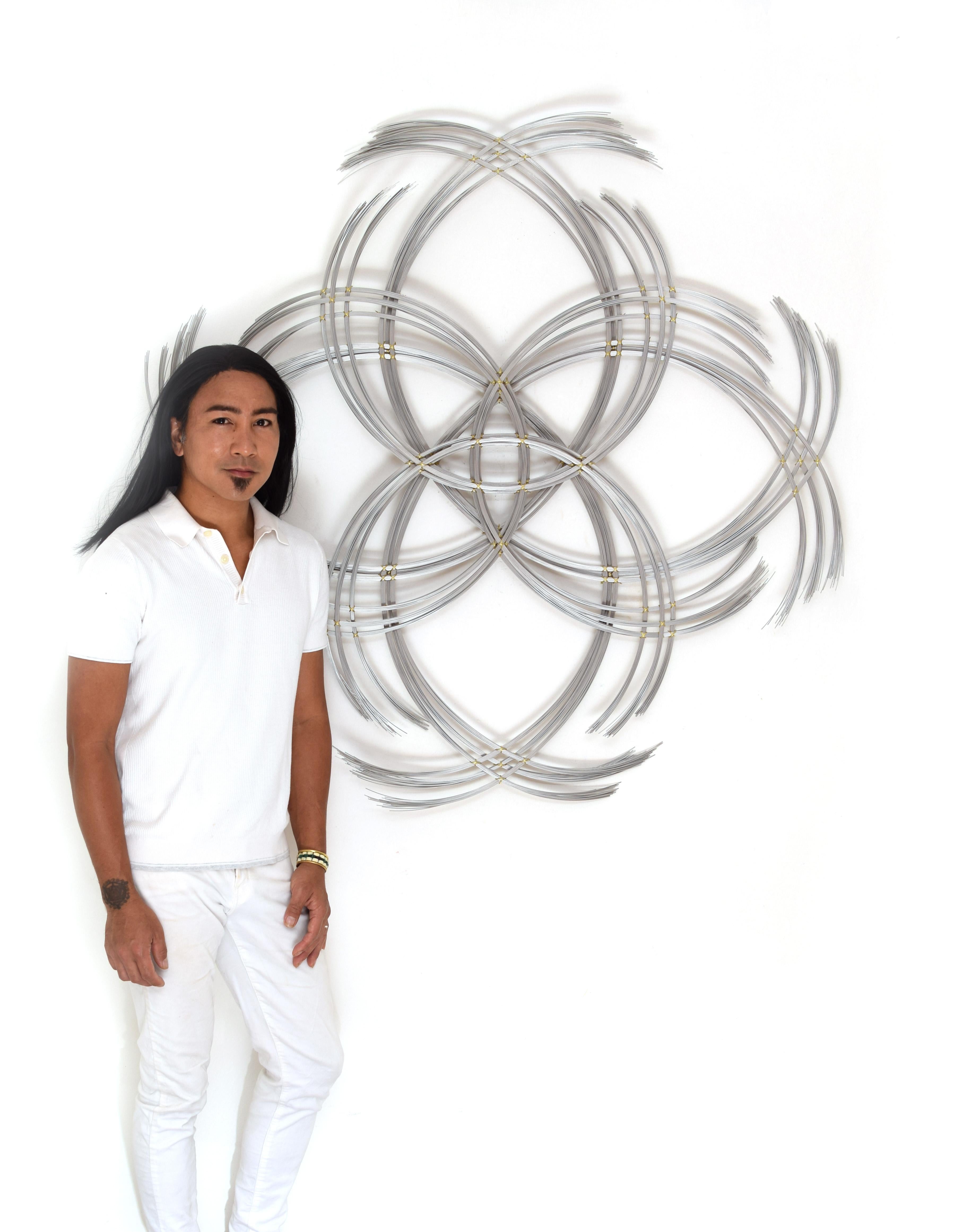 Matte finish stainless steel. 

This abstract wall art by Kue King is created using matte-finish stainless steel wire. Kue uses an aesthetic reminiscent of trees, electricity, and light to create sculptures of peace and beauty. Adults and children