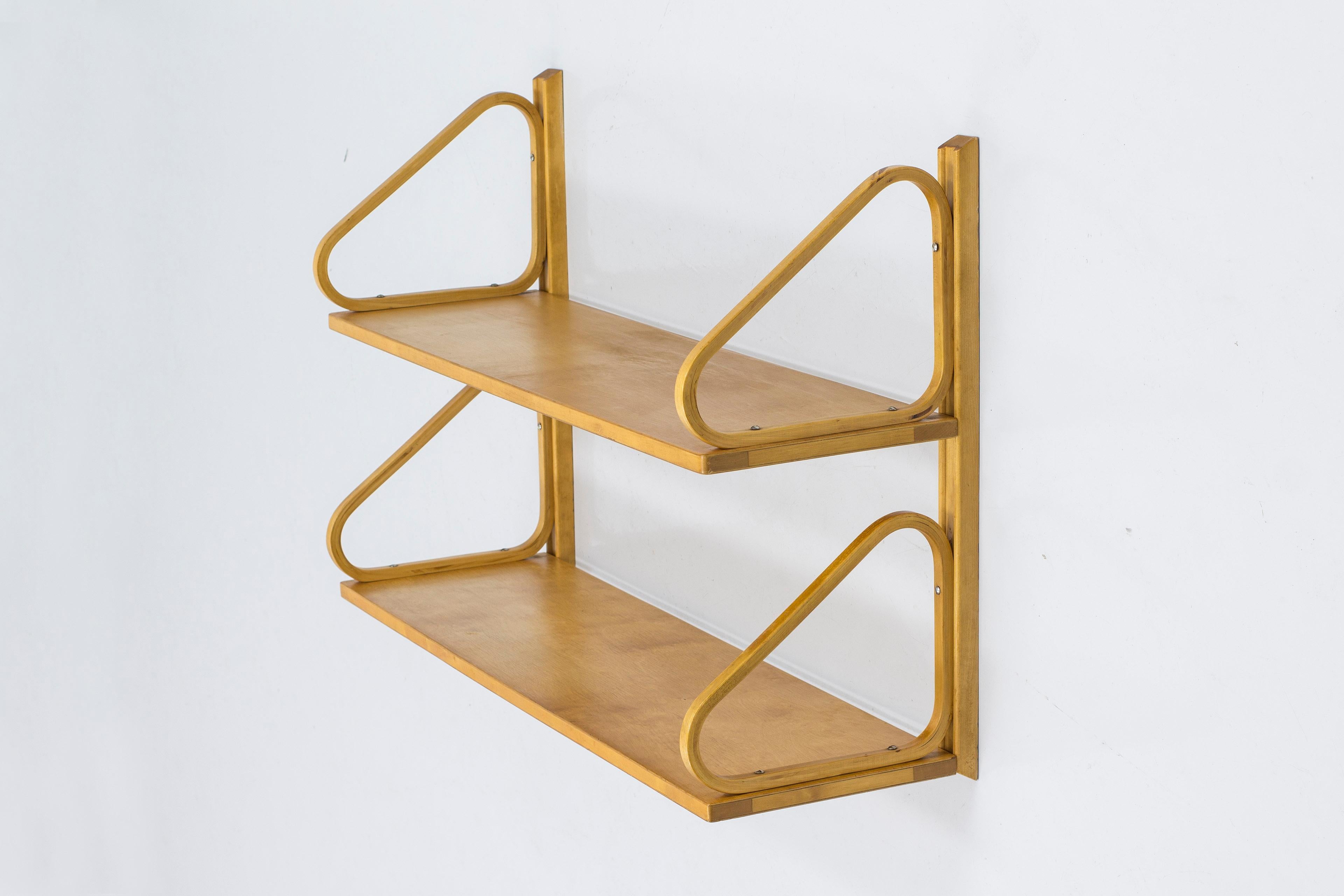 Wall shelf designed by Alvar Aalto. Produced by Svenska Artek in Hedemora, Sweden. Made between 1946-1956. Mad from solid and laminated birch throughout. Beautiful honey toned color from age and patina. The shelf comes with original wall mount but