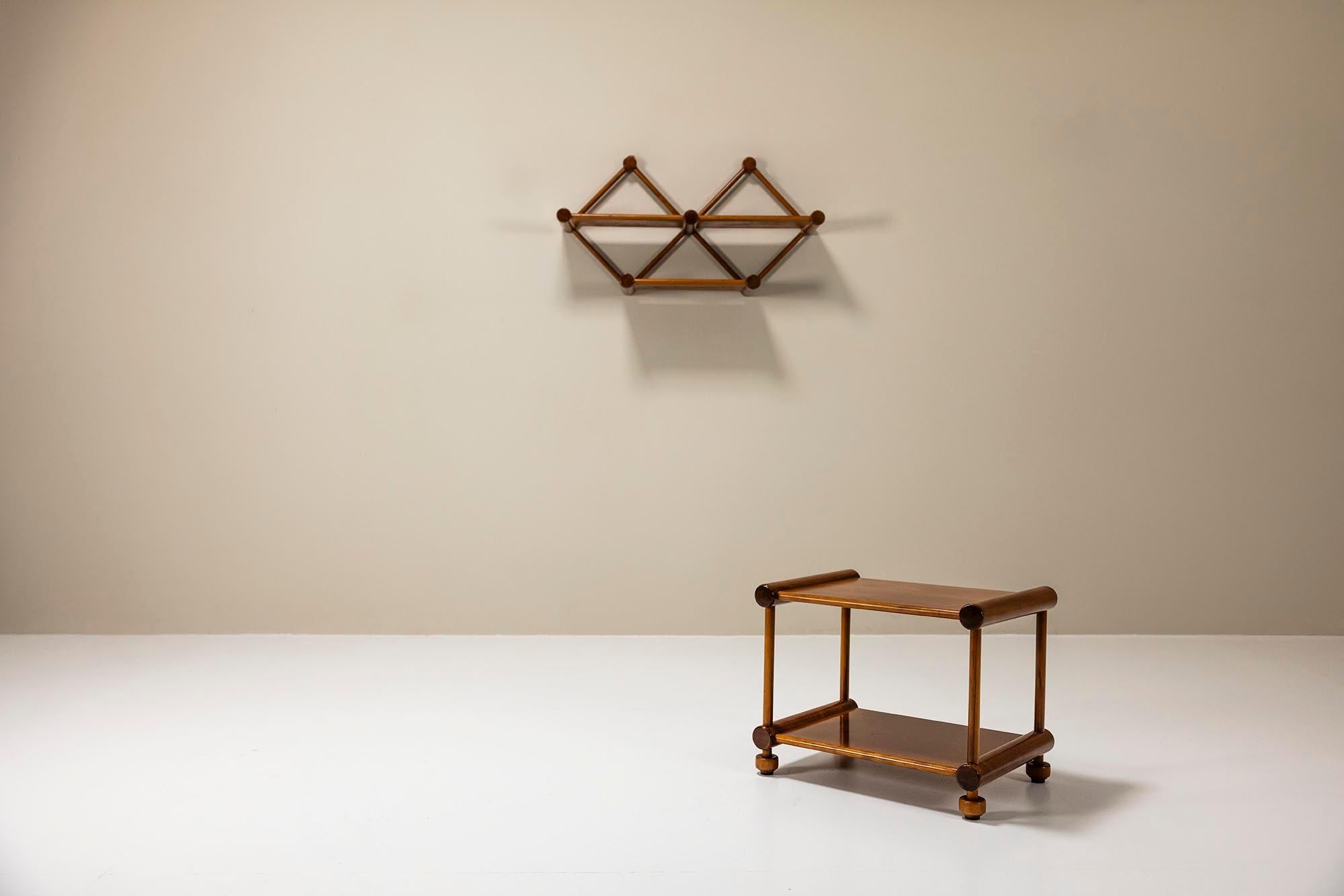 El lenguaje de diseño de esta atractiva combinación tiene un alto valor decorativo. Las formas geométricas determinan el marco de la estantería de pared y la mesa auxiliar. Los elementos que componen este hermoso conjunto son cilindros grandes y