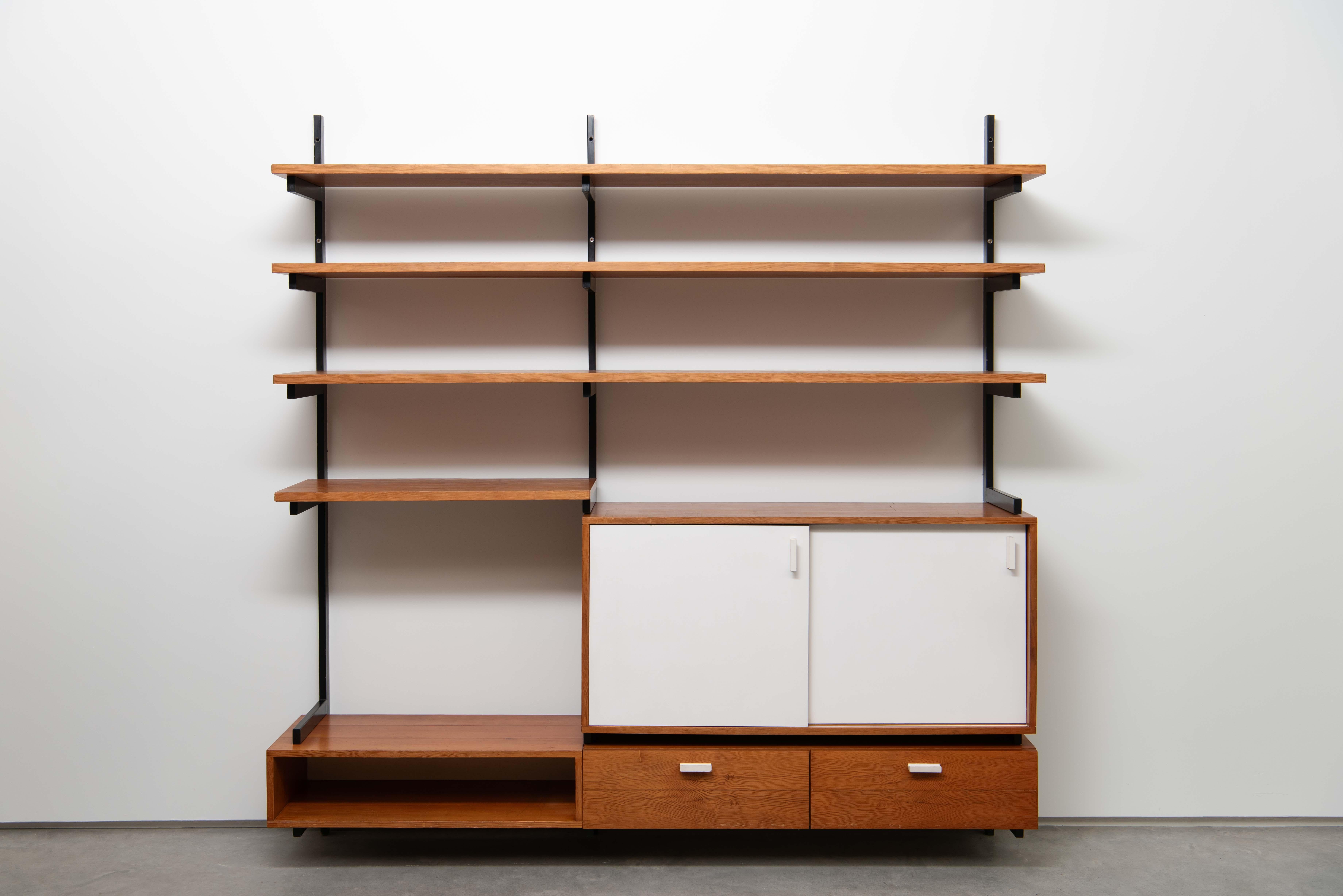 Un mobile da parete in pino con struttura in acciaio verniciato nero. Progettata per una casa ad Anversa dall'architetto d'interni belga Jul de Roover negli anni Cinquanta. 

L'unità è composta da un mobile profondo a doppia larghezza e da 2