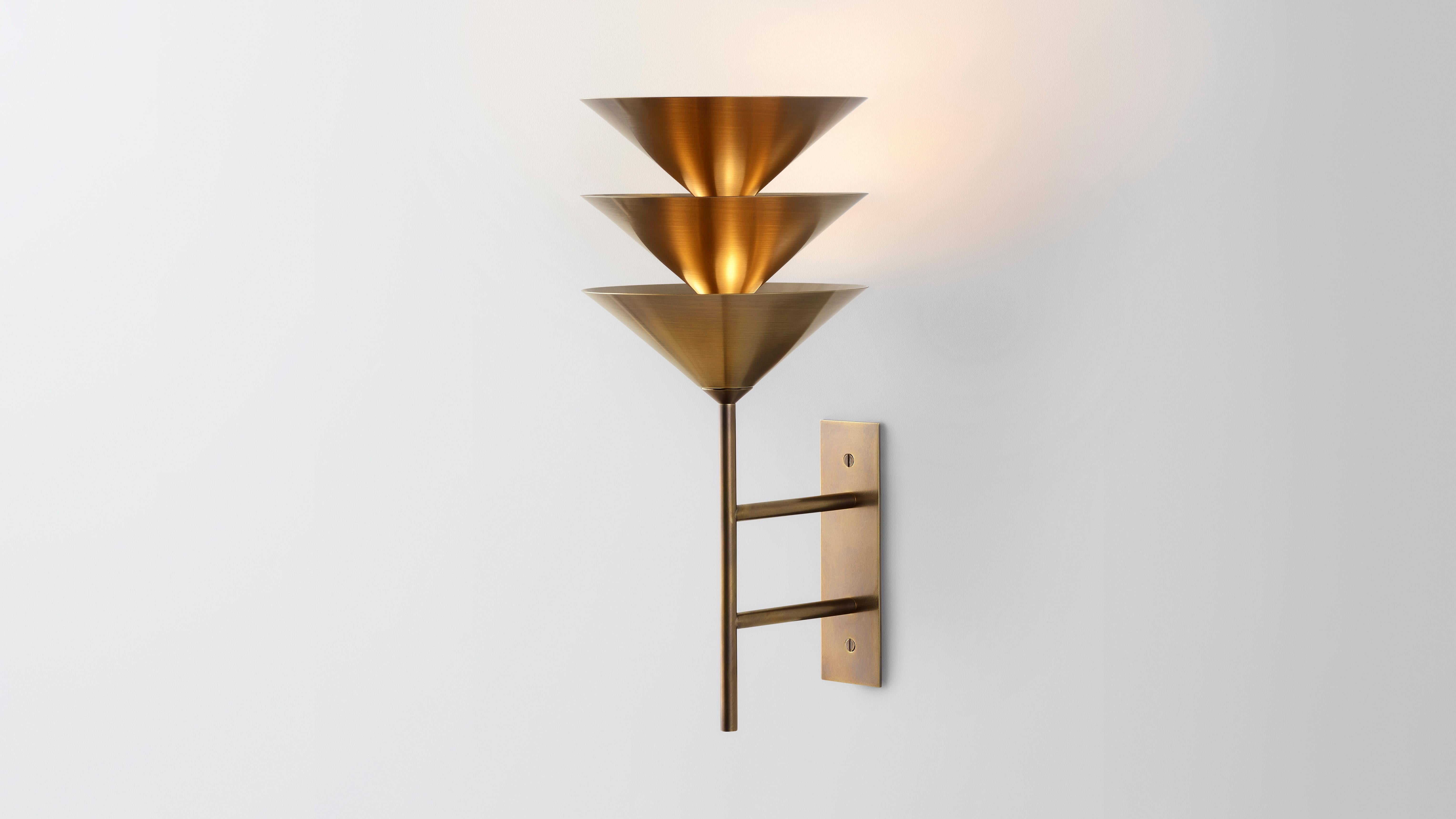Wall stack 3 by Volker Haug
Pyramid Scheme series
Dimensions: W 21, D 24, H 46 cm
Support: 20 cm 
Material: Brass
Finishes: Polished, brushed or bronzed brass; enamel or chrome-plated.
Custom finishes available on request.

Lamp: 12V G4 LED x