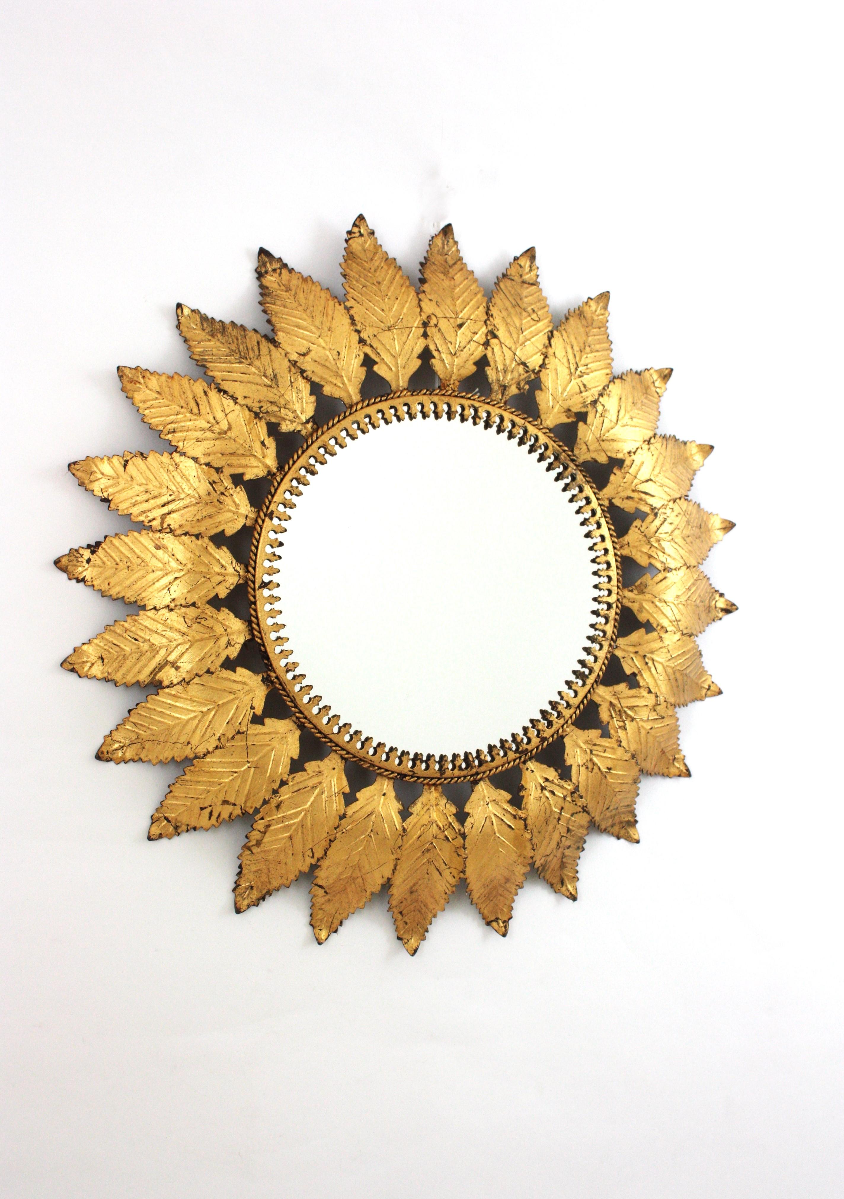 Specchio rotondo a raggiera in ferro dorato con cornice di foglie, Spagna, anni 1950-1960.
Un accattivante specchio a raggiera incorniciato da grandi foglie smerlate in metallo con finitura dorata.
Questo specchio è in ottime condizioni vintage e