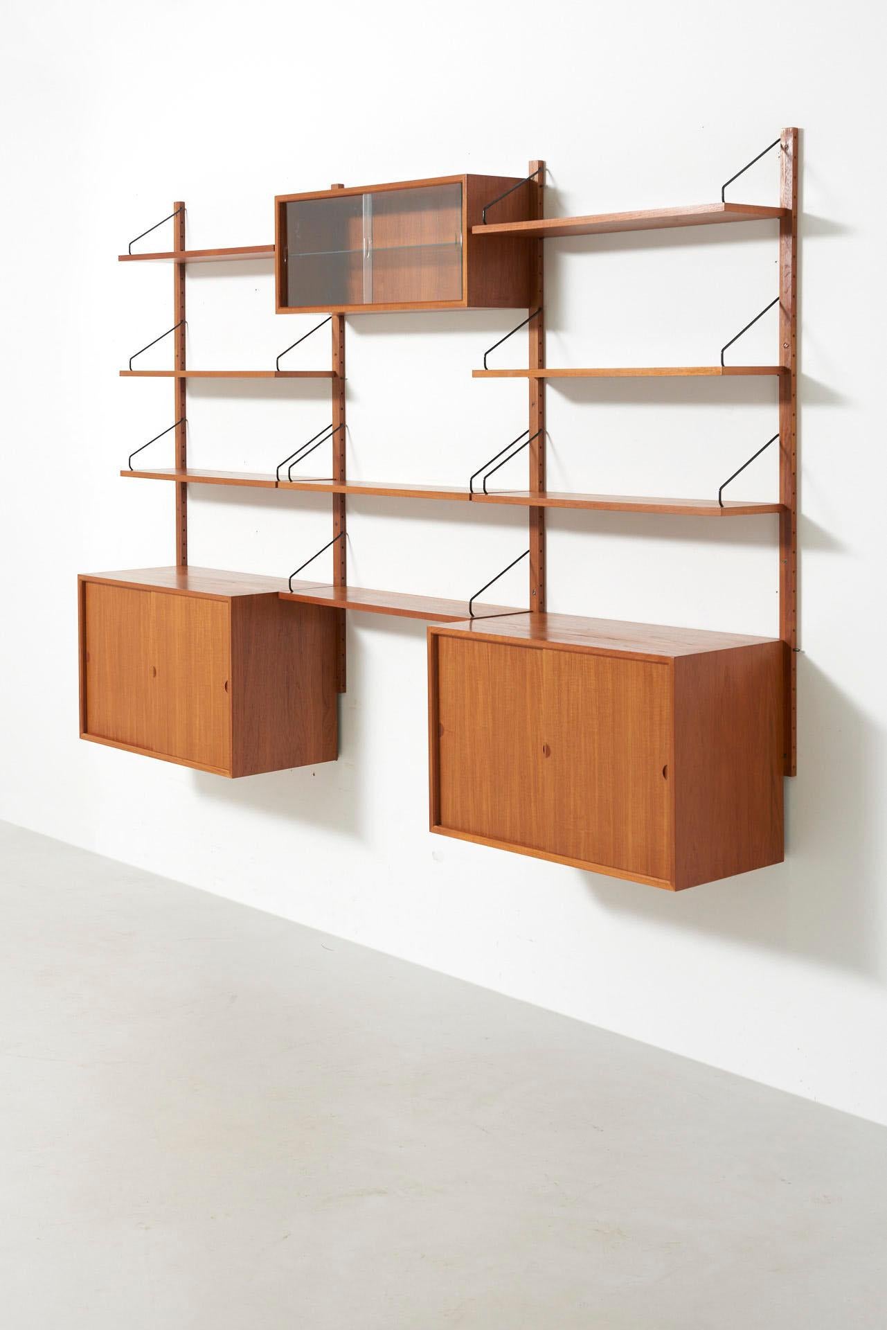 Wall unit in teak by Cadovius. Consisting 2 cabinets and 8 shelves.