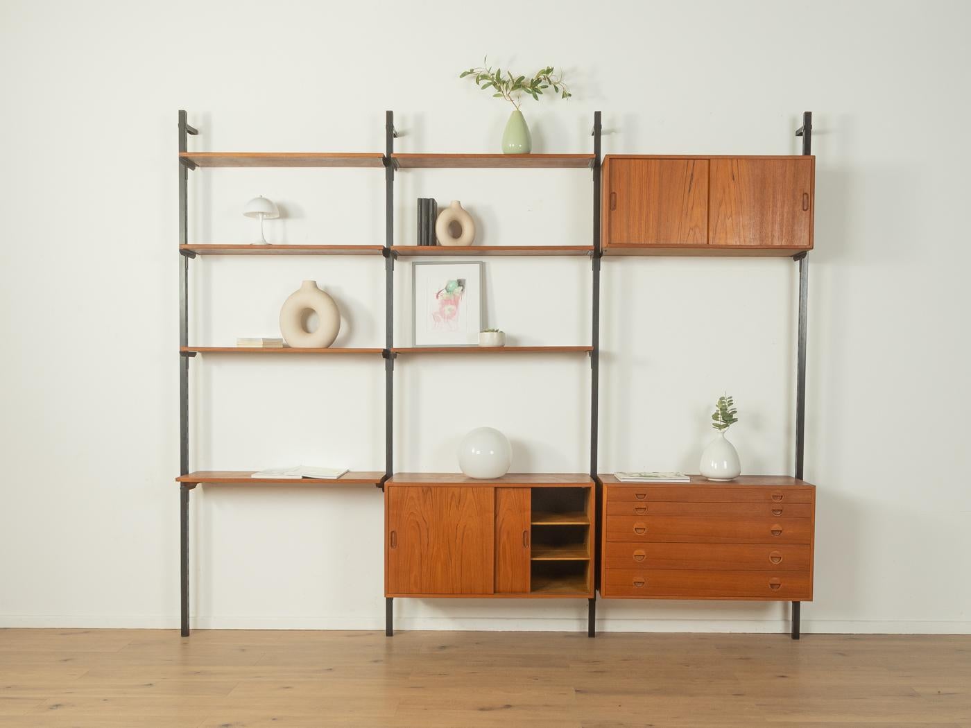Sistema di scaffalatura classico degli anni '60 di HG Furniture. I contenitori e i ripiani di alta qualità sono impiallacciati in teak. Il sistema è composto da sette scaffali, un contenitore con cinque cassetti, due contenitori con porte scorrevoli