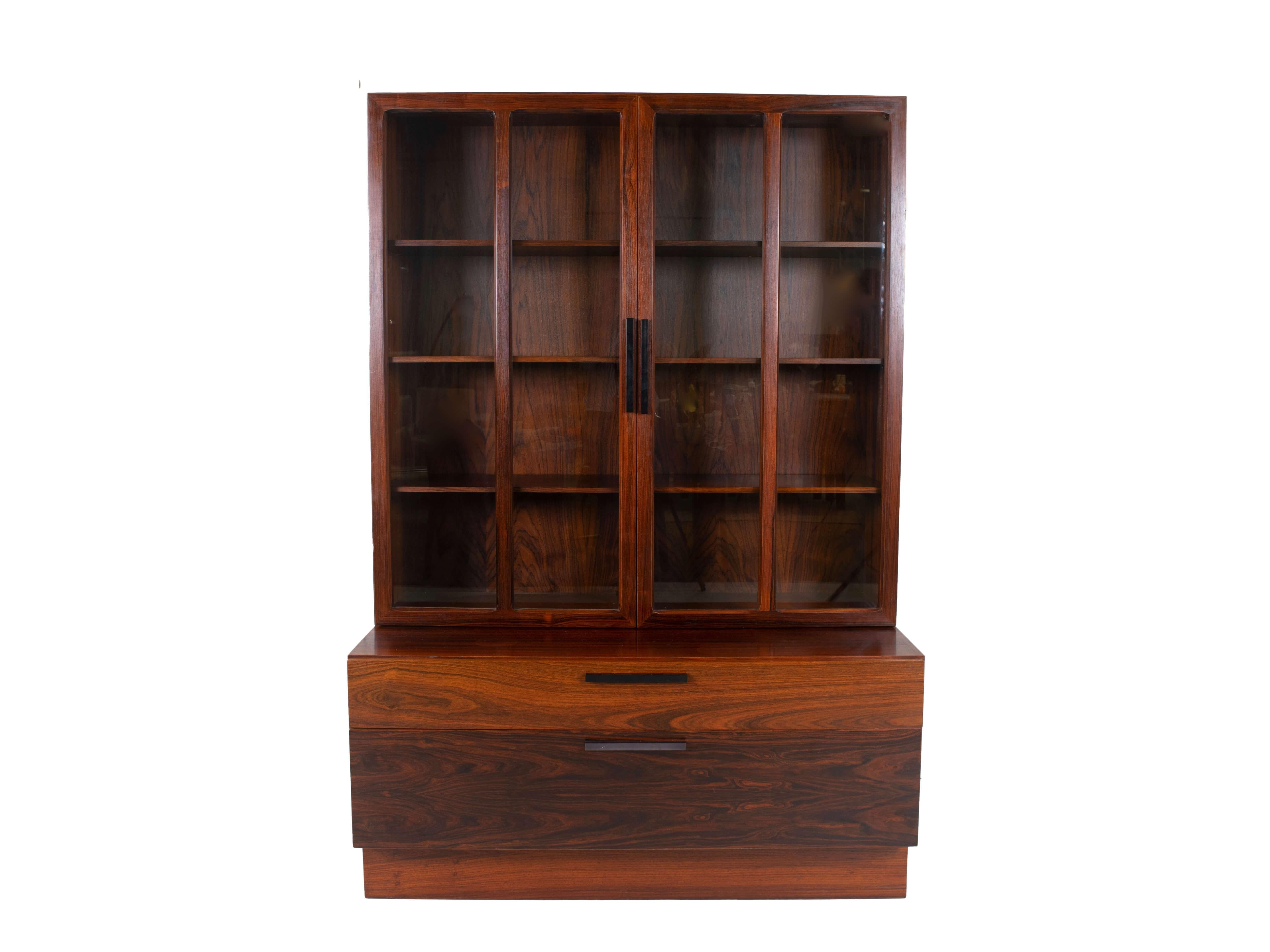 Wall unit by Ib Kofod-Larsen for Faarup Møbelfabrik in Rosewood from Denmark 1960s. This unit consists of two elements that are not connected; a display cabinet and a cabinet with two drawers. The display cabinet has two doors with glass and black