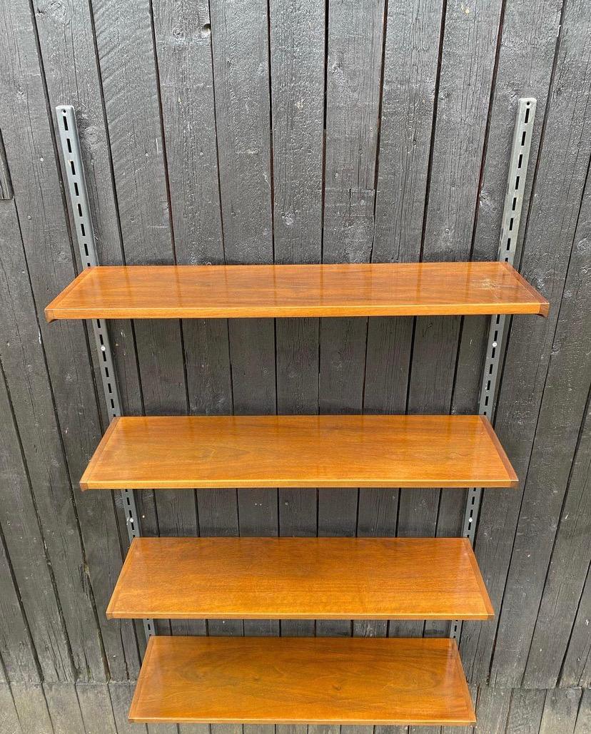 Small wall unit with 4 shelves in nutwood, as you don't see that often.

The 2 support rails meassures 150 cm and it's possible to place the shelves where it fits you.

Good vintage condition.


