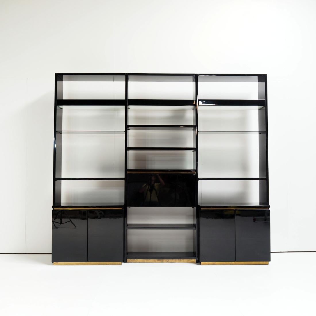 Beautiful wall unit designed in the 1970s by the French luxury designer Jean Claude Mahey.

The wall unit consists of three compartments, each with shelves and storage space where the middle compartment is a bar. Brass, glass and high-gloss