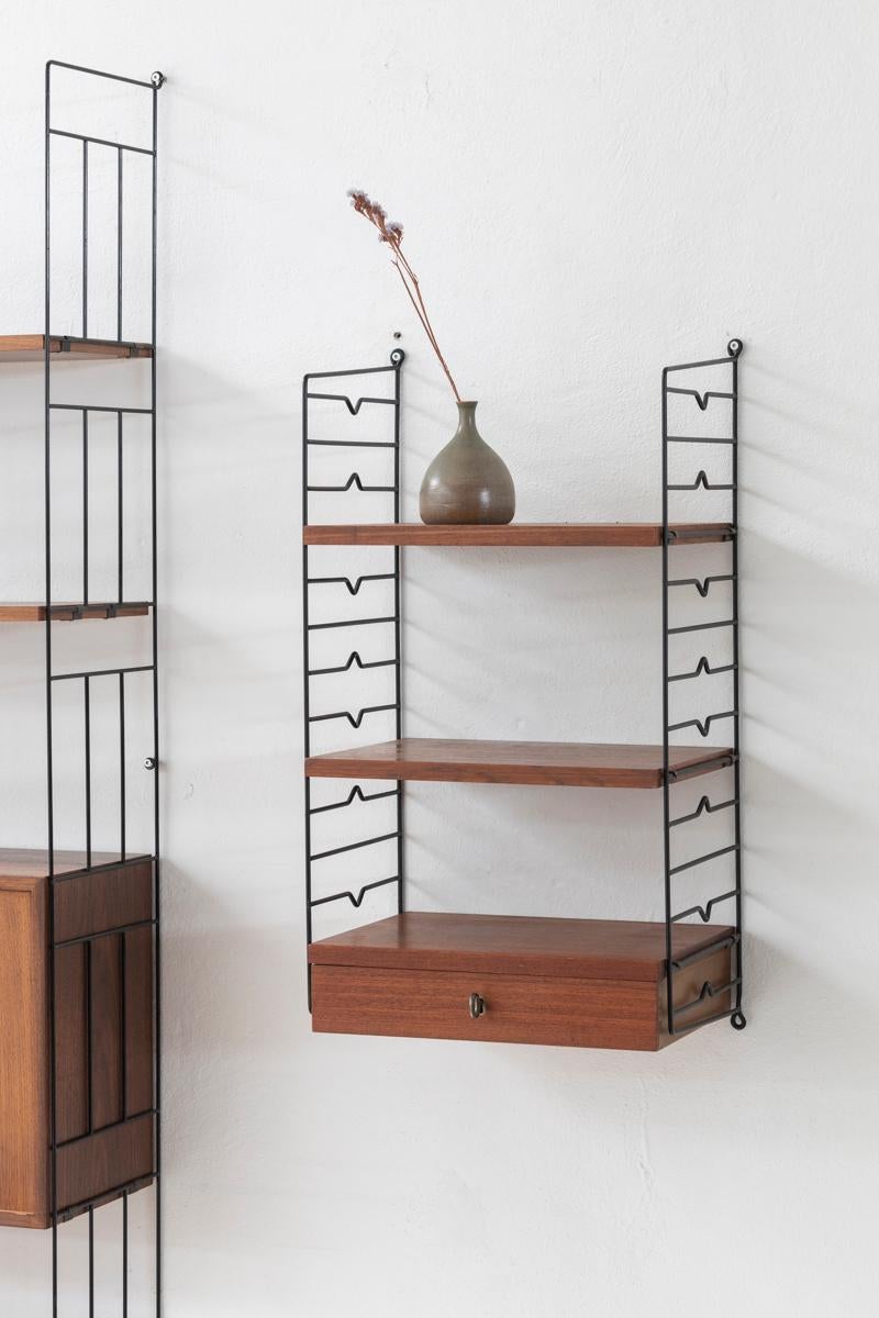 Wall unit designed by Nisse Strinning and produced by String in Sweden around 1960. This cute little wall unit contains one small drawer with the original key and two shelves, each with a depth of 30 cm. The wall unit is in very good condition as