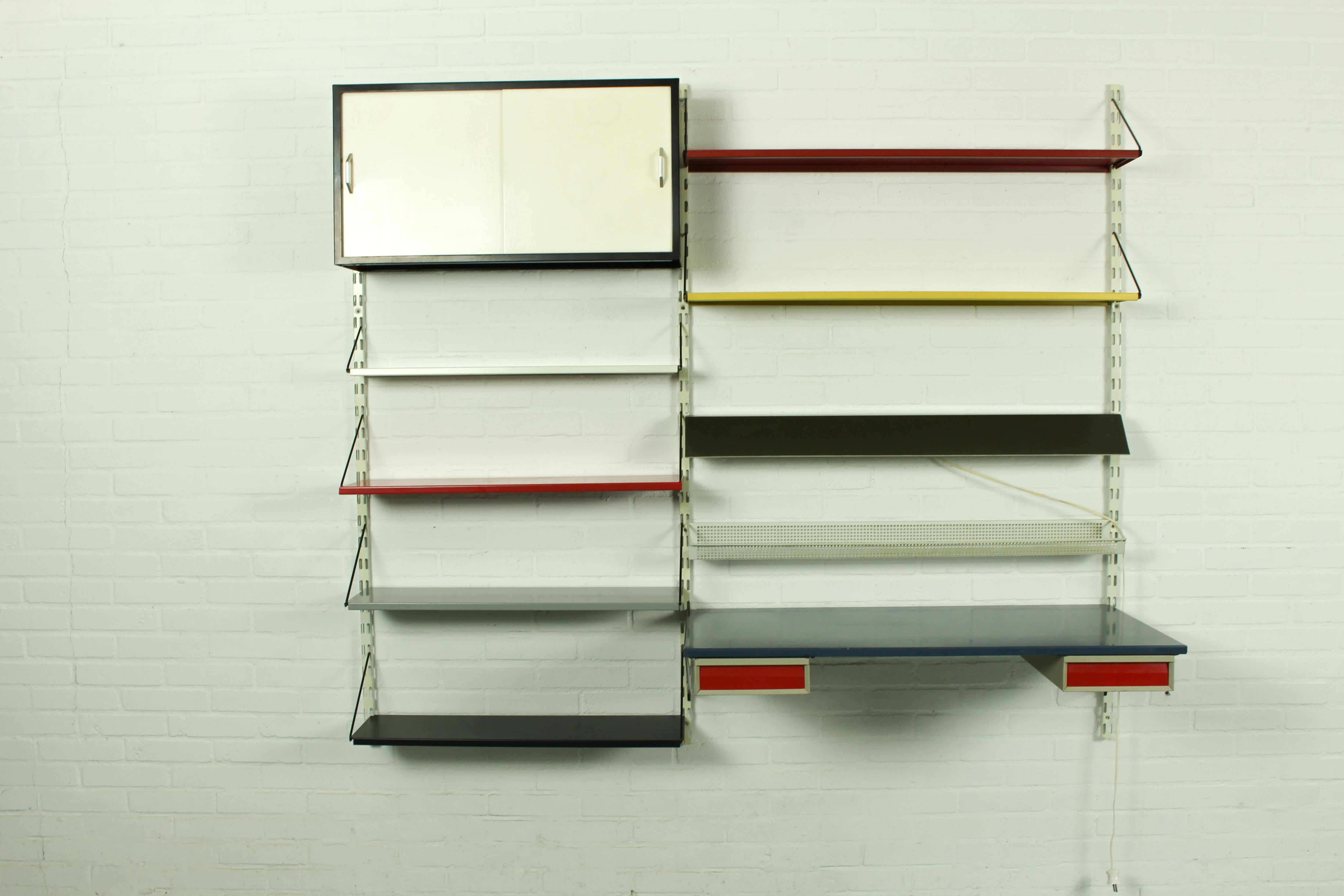 Vintage industrial wall system / bookshelves, designed by Tjerk Reijenga for Pilastro, Holland 1960s. Very nice and complete wall unit with some rare pieces included, it contains a cabinet, a die cut shelve for desk utensils, grey lamp, a desk