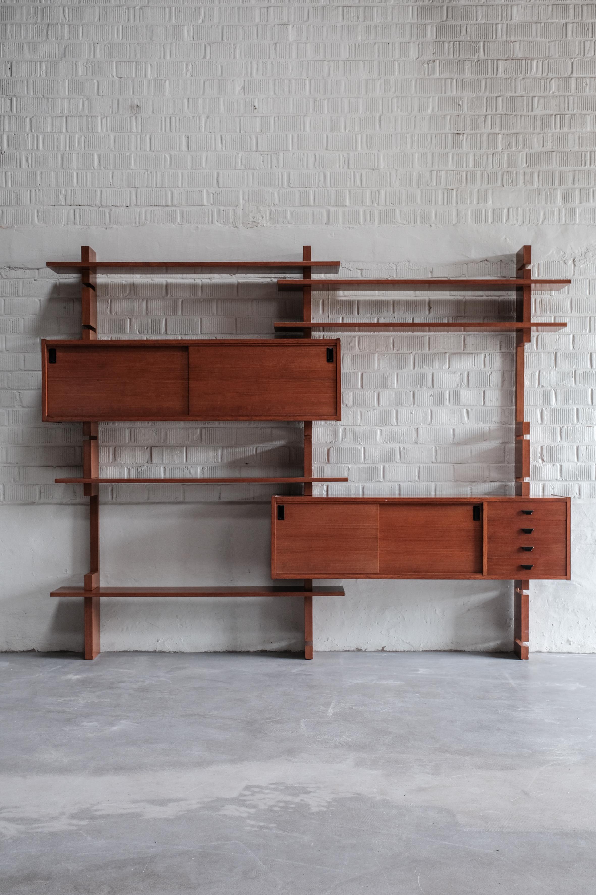 This rare wall unit designed by Amma Torino is in excellent condition.
The wall unit counts: 2 cabinets, 5 shelves and 3 vertical slats.

Units are fixed to the wall (invisible). 