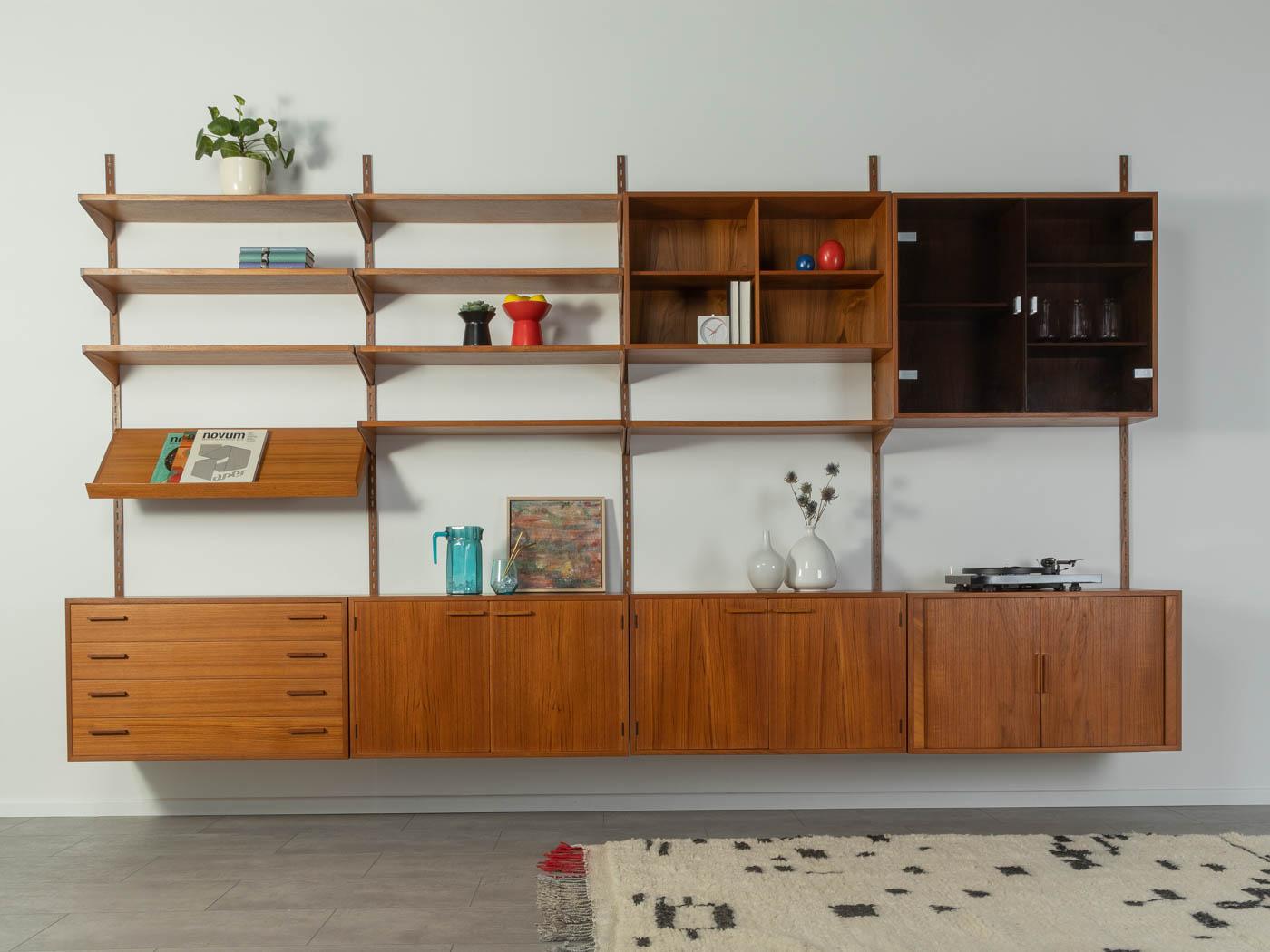 Classic shelving system by Kai Kristiansen for FM Mobler from the 1960s. The high-quality containers and shelves are veneered in teak. The system consists of eight shelves, two containers with doors, a container with four drawers, a container with